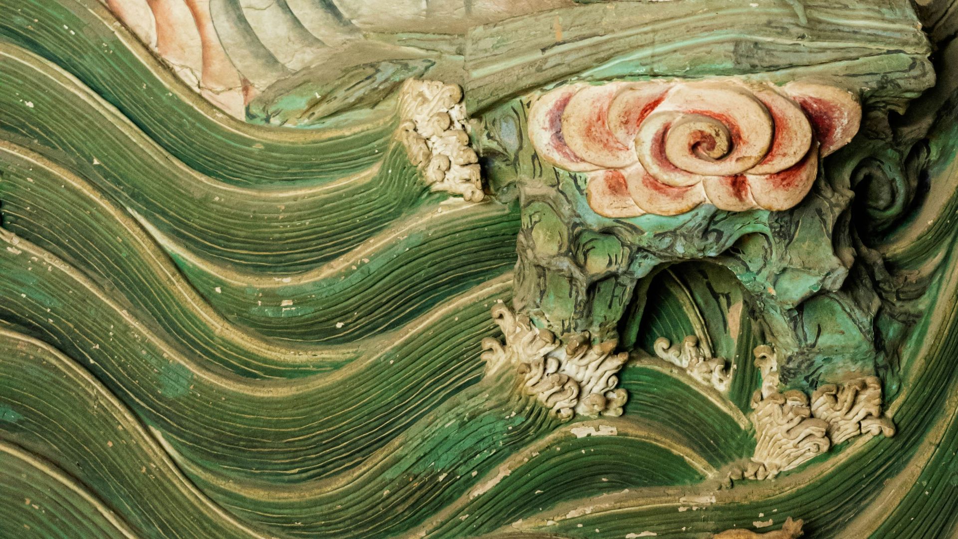 Elaborate carving depicts a figure amidst landscape elements.