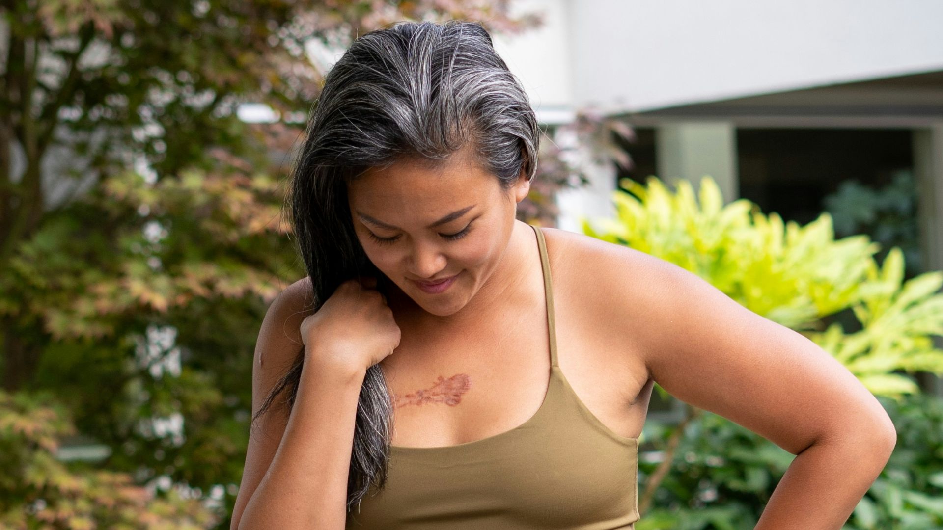 woman in brown bra and brown pants standing on gray concrete pathway during daytime