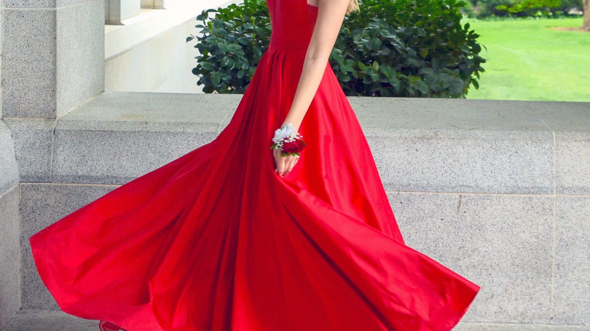 woman in red sleeveless dress standing on gray concrete floor during daytime