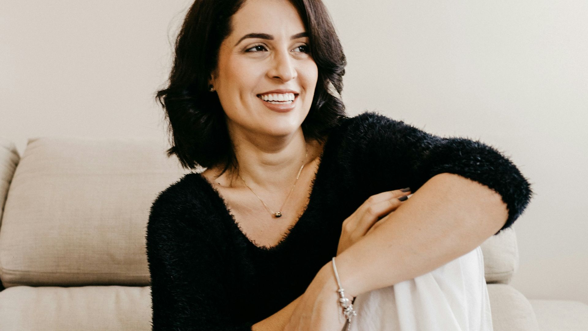woman in black long sleeve shirt sitting on white couch