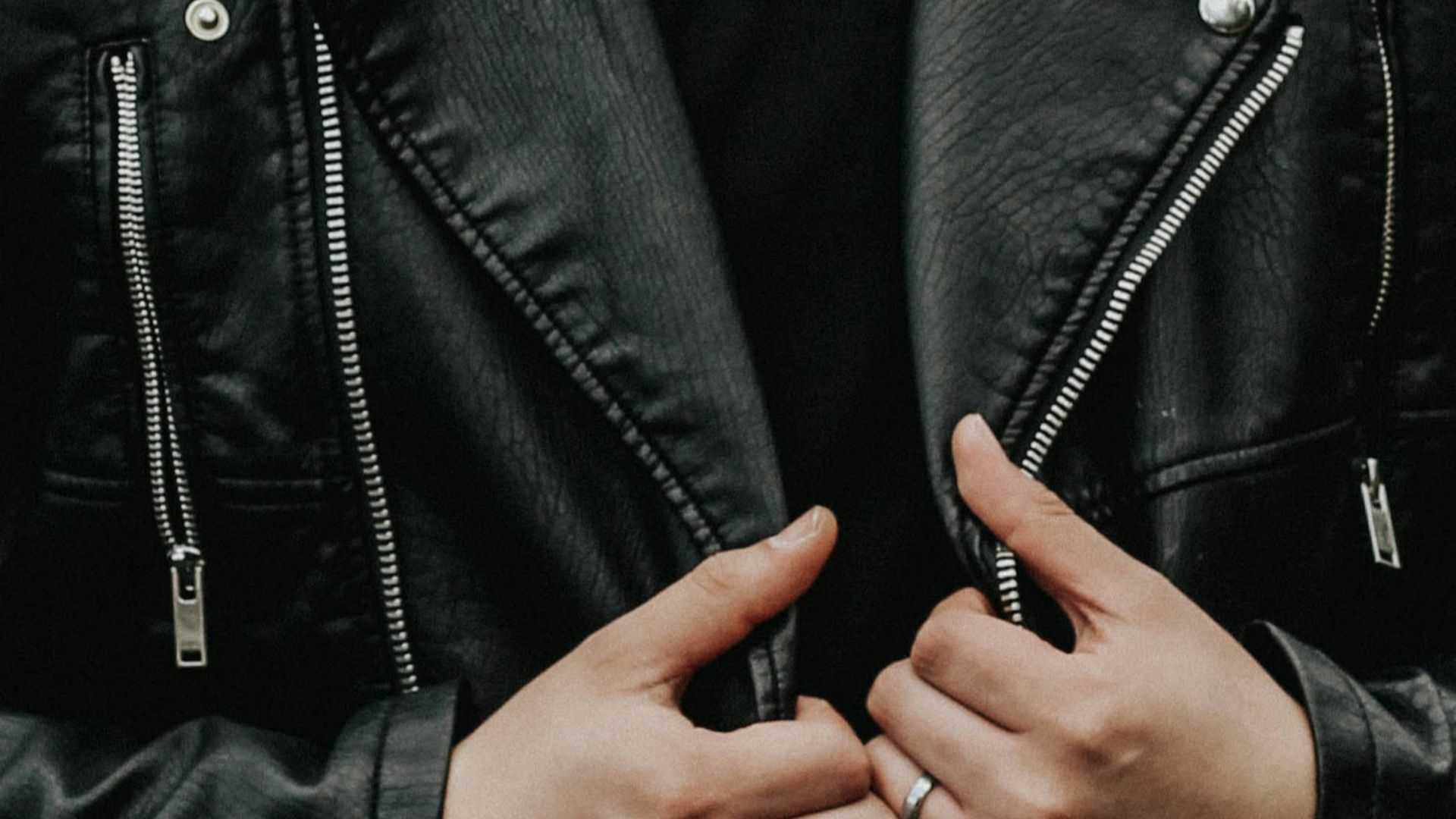 man holding his leather jacket
