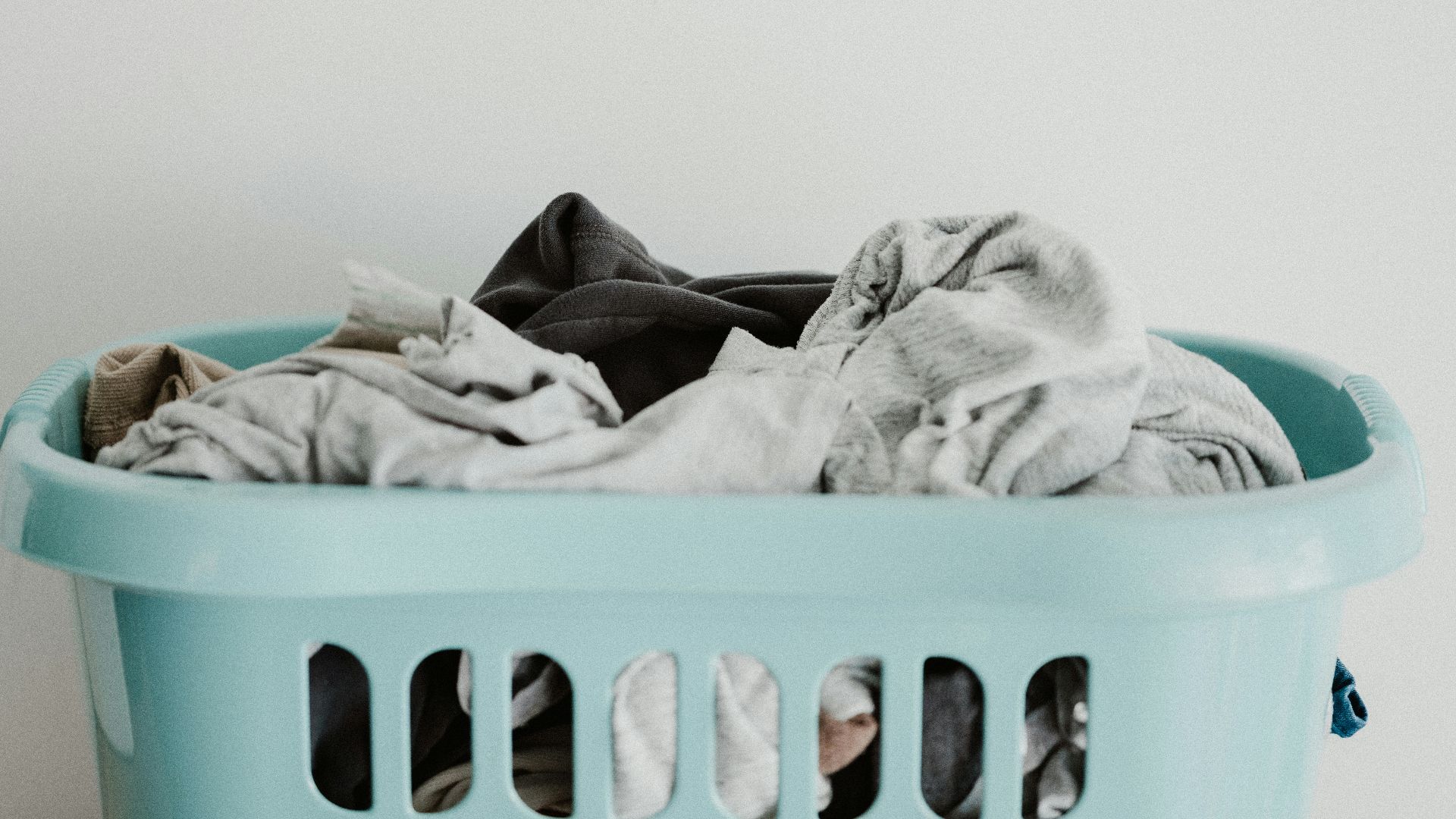 white textile on blue plastic laundry basket