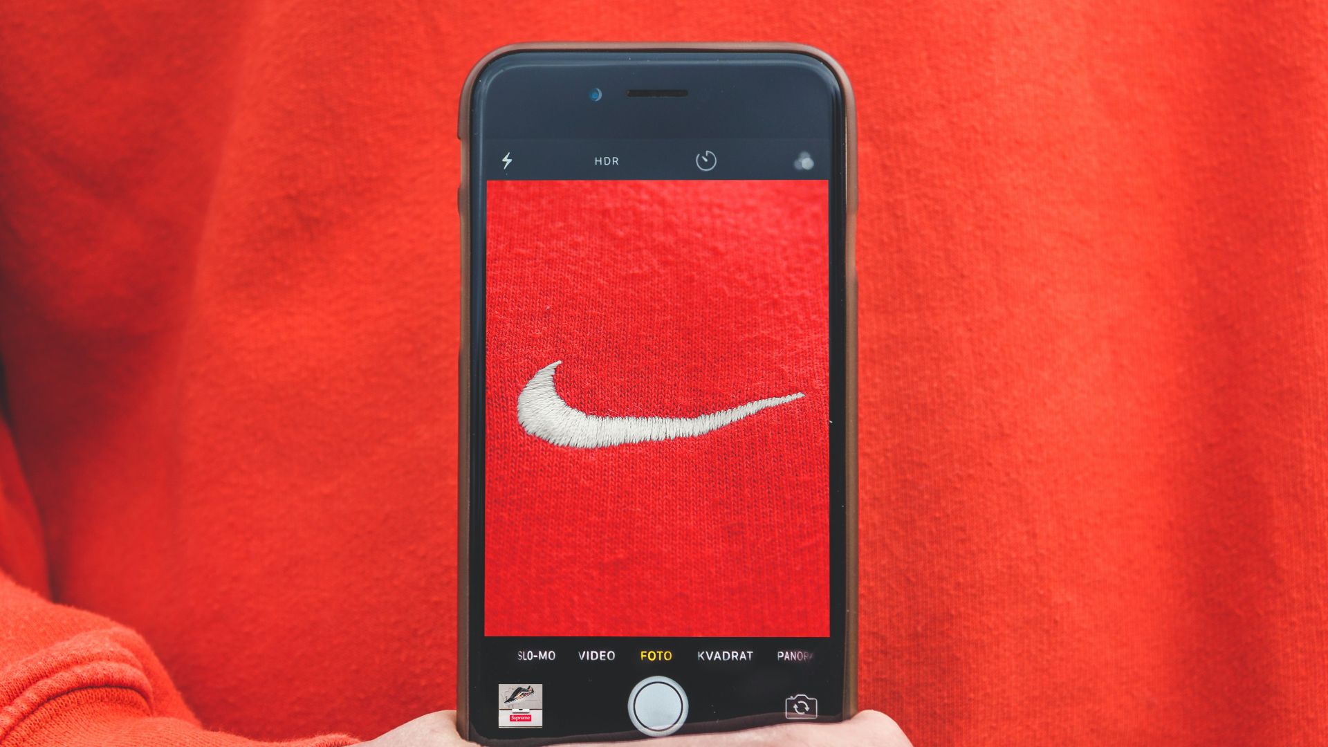 person holding iPhone taking picture on Nike label