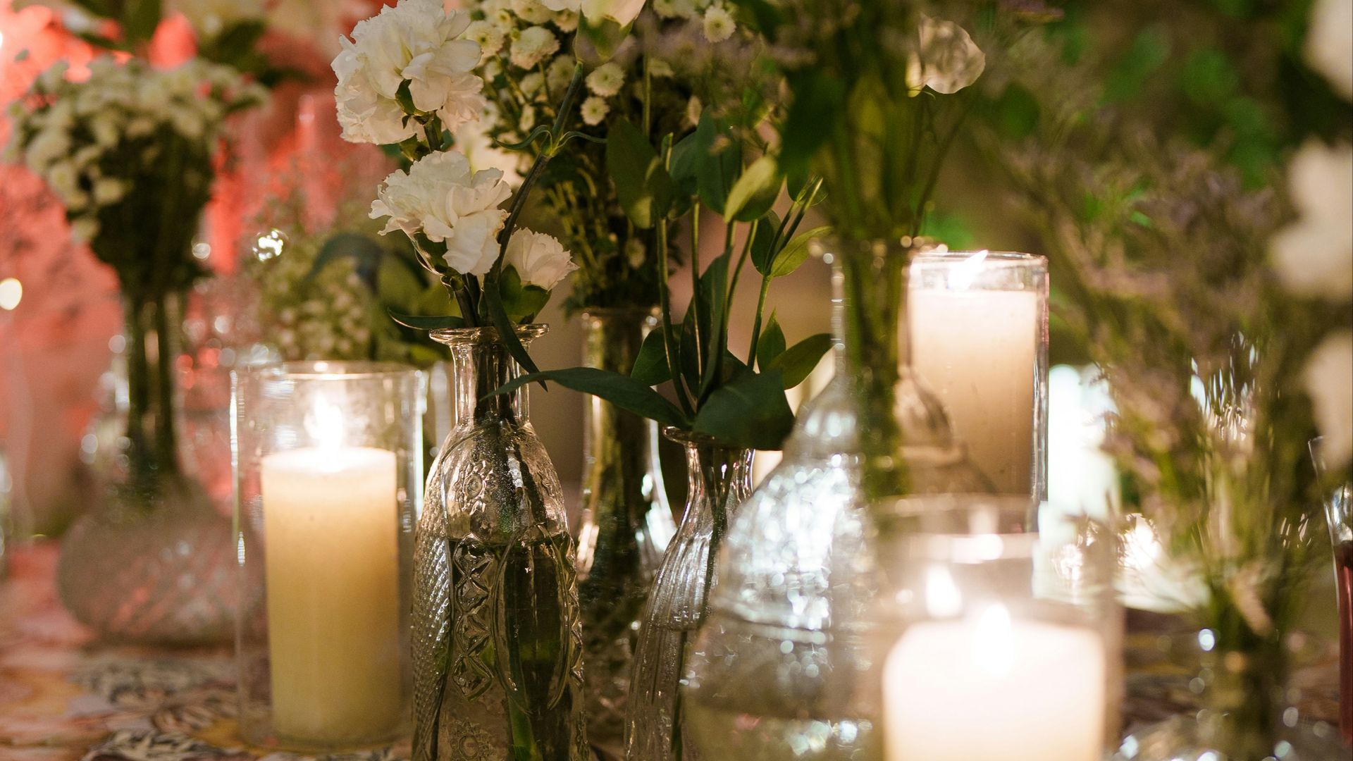 Flowers and candles adorn a festive table setting.