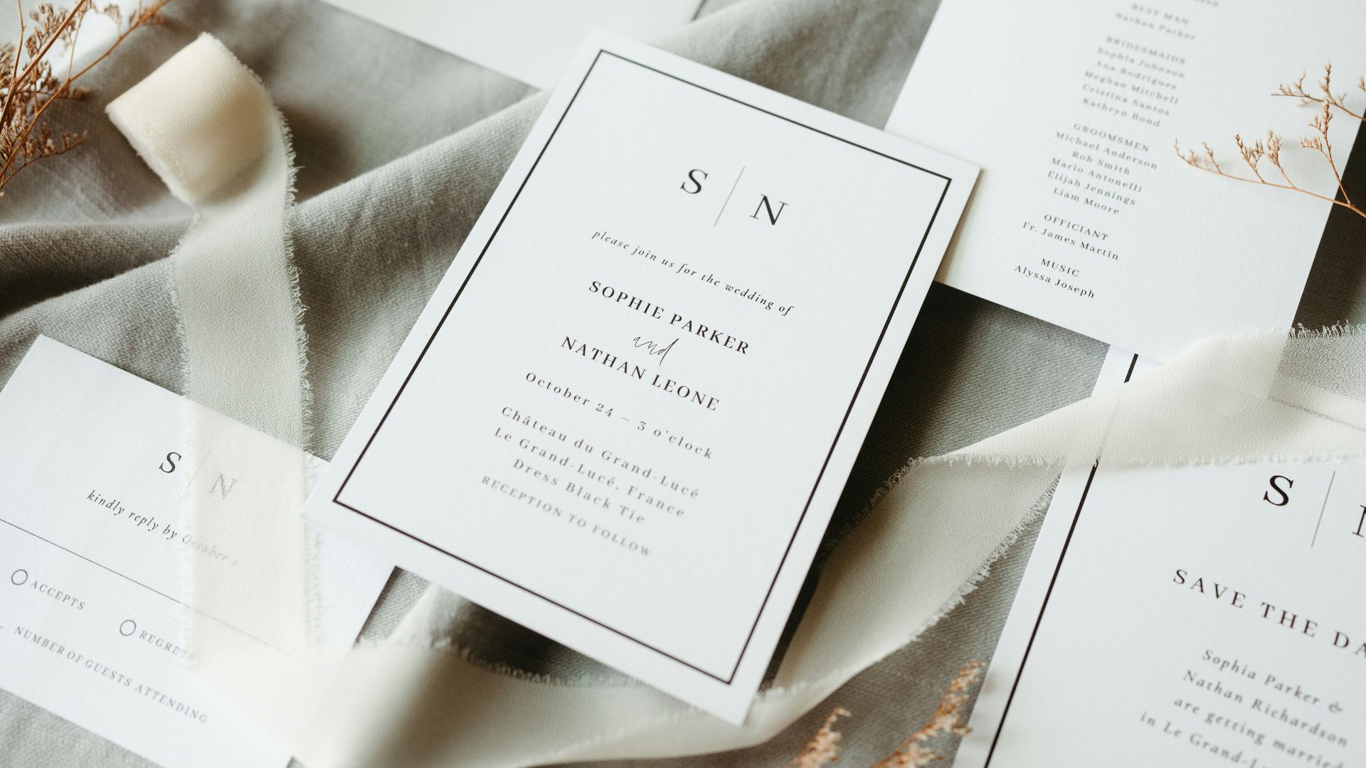 Wedding stationery is arranged on fabric.