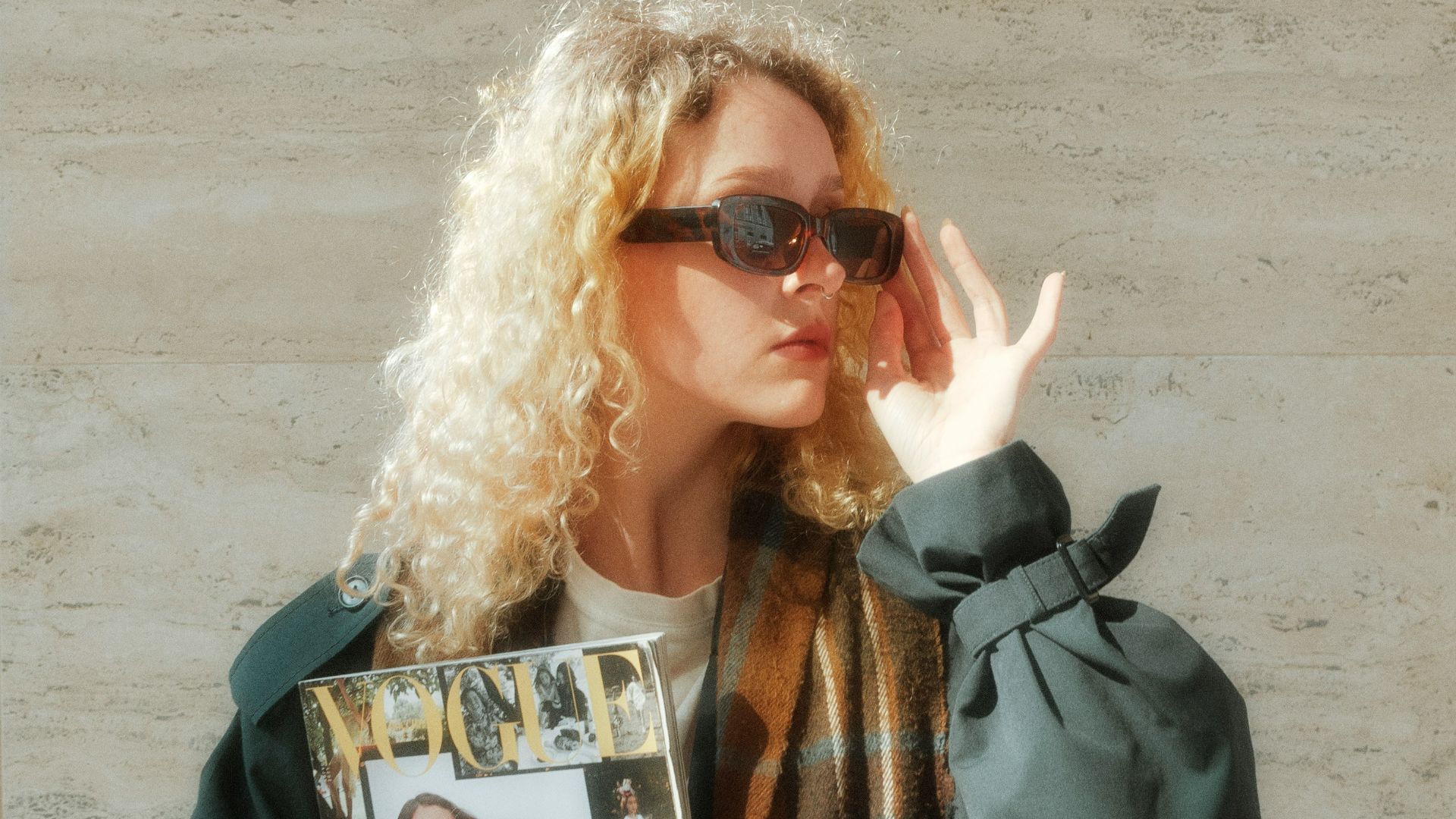 a woman holding a magazine and a purse