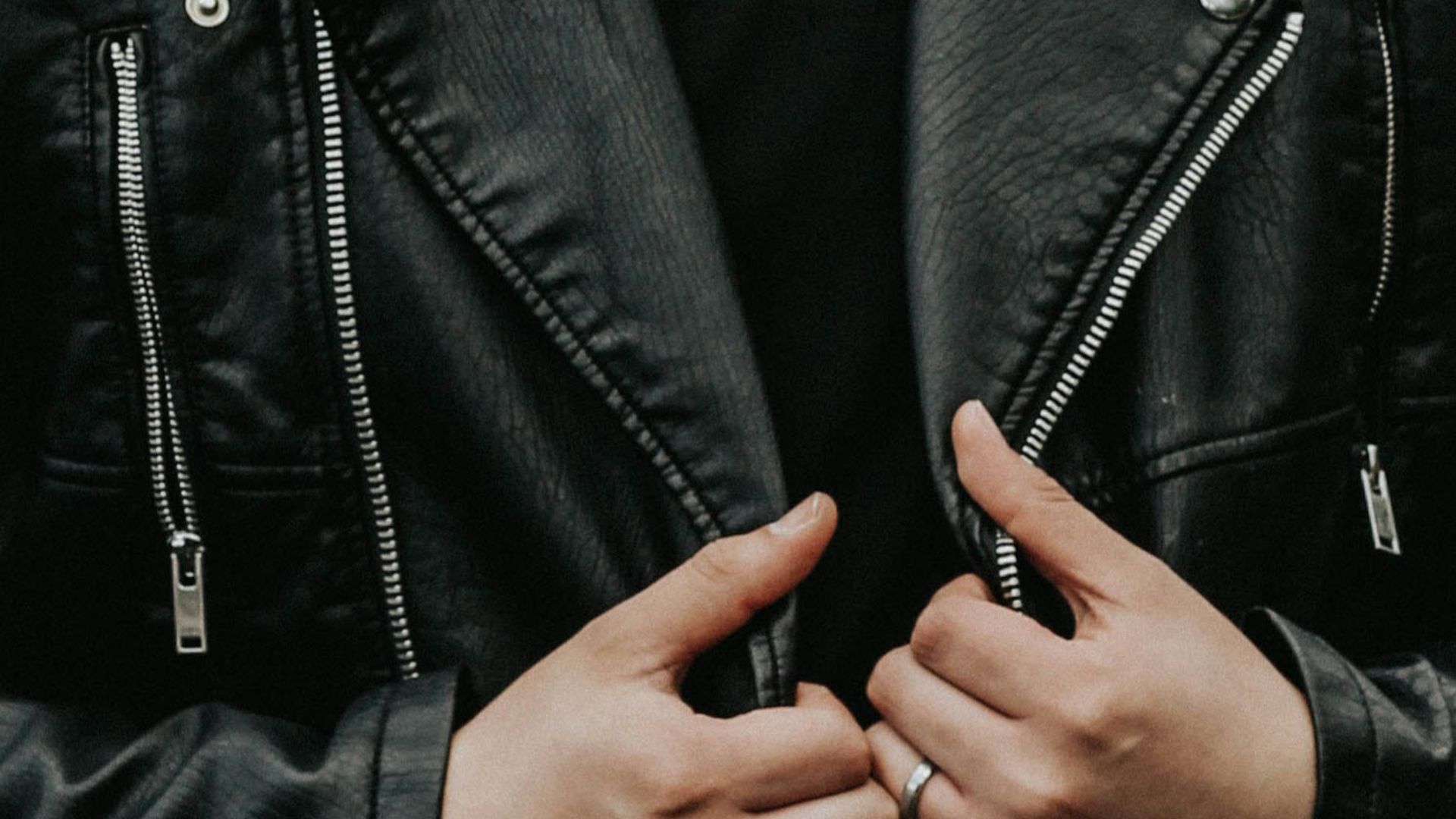 man holding his leather jacket