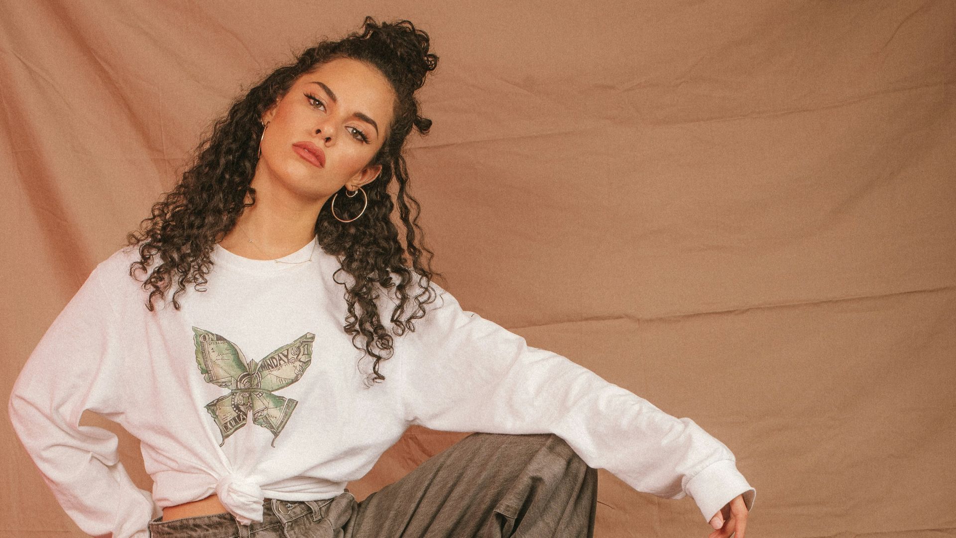 man in black and white long sleeve shirt and gray denim jeans lying on brown couch