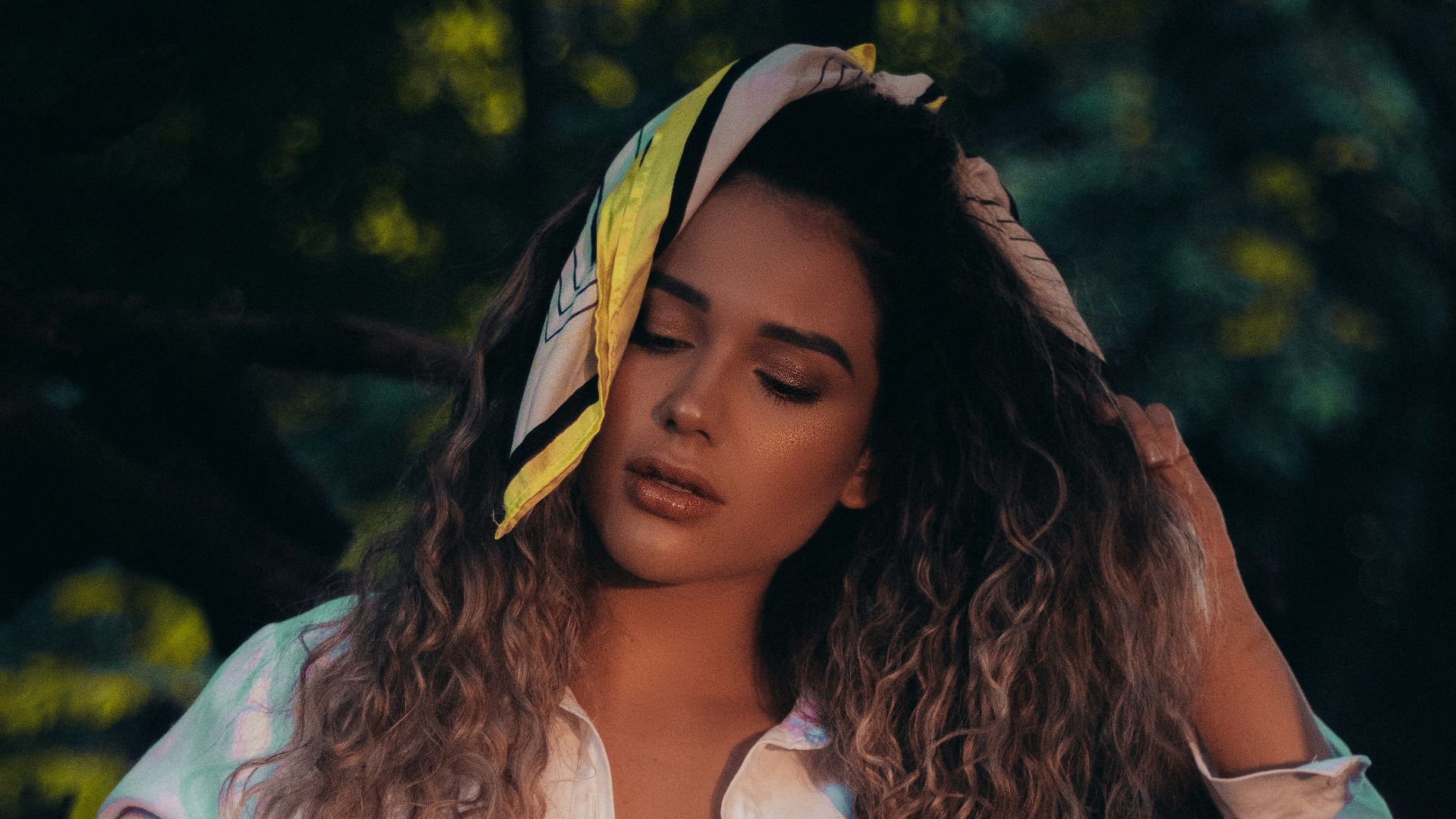 woman in white dress shirt and blue denim shorts standing near green trees during daytime