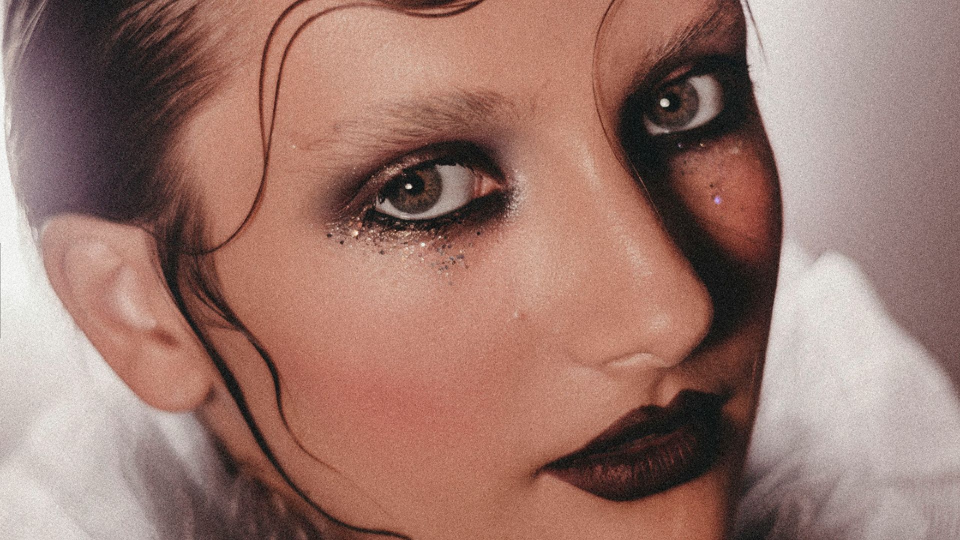 a woman with makeup on her face and hair