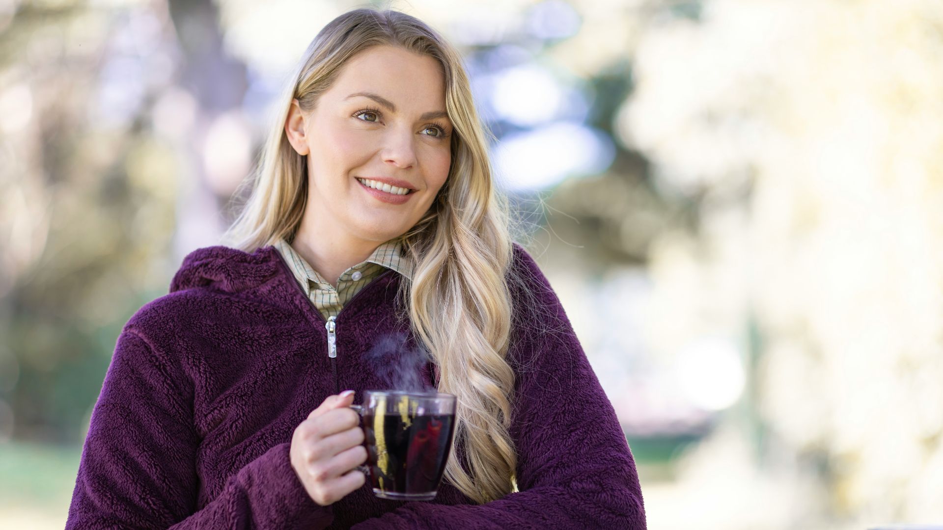 A woman sitting at a table with a cup of coffee