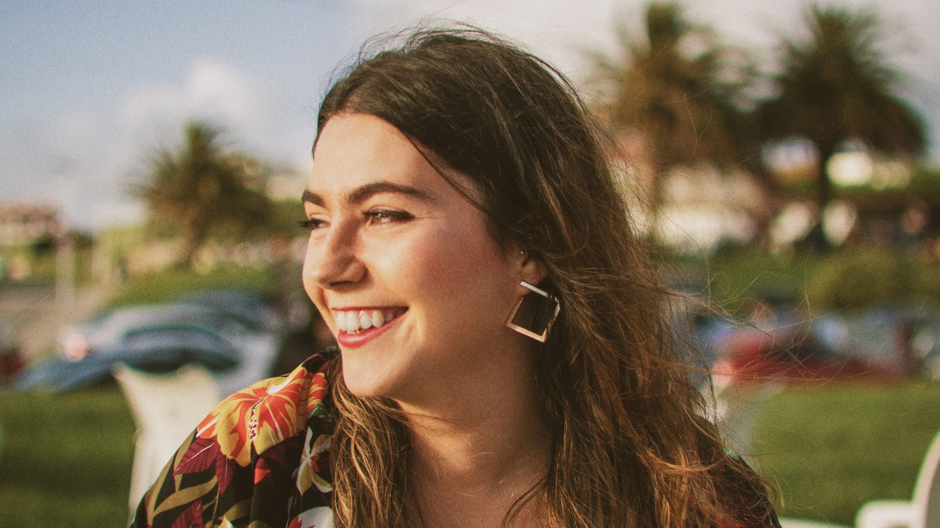 smiling woman wearing black and orange floral top