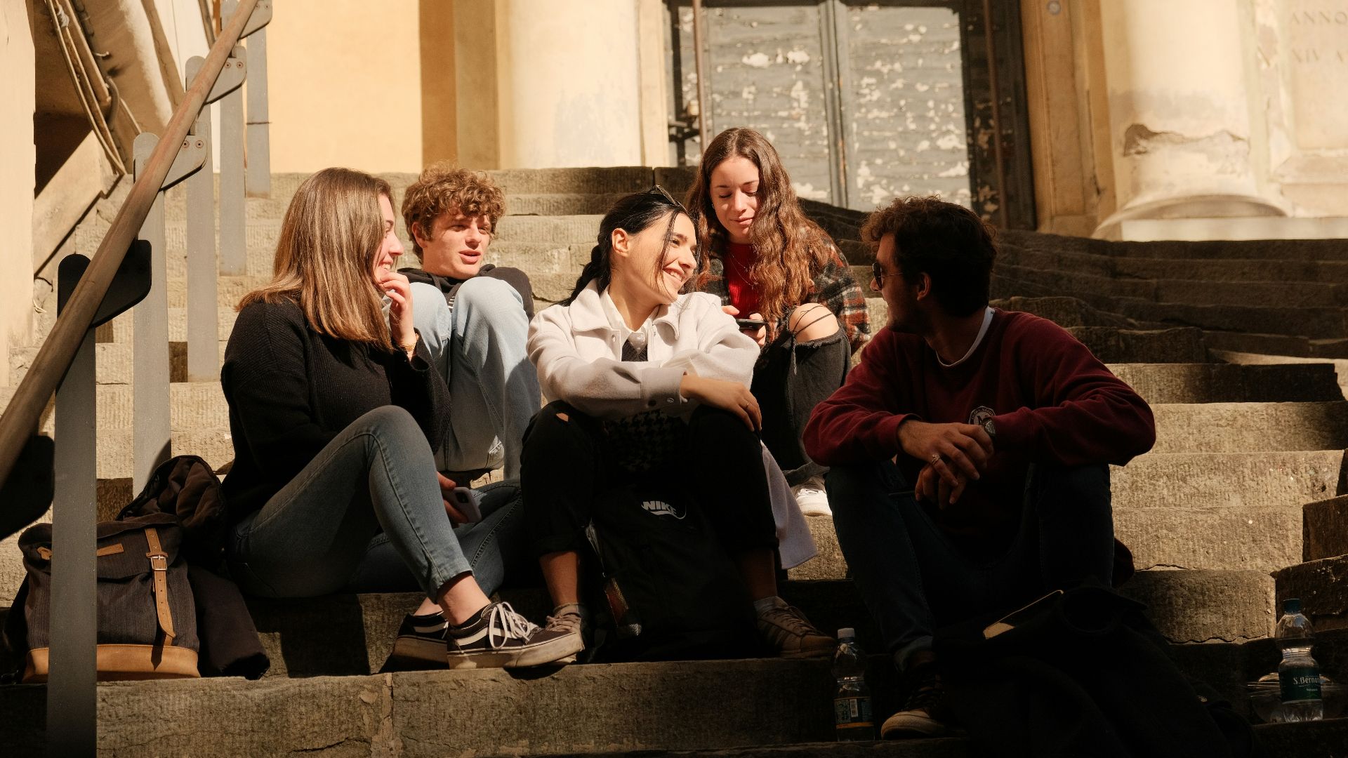 a group of people sitting on the steps of a building