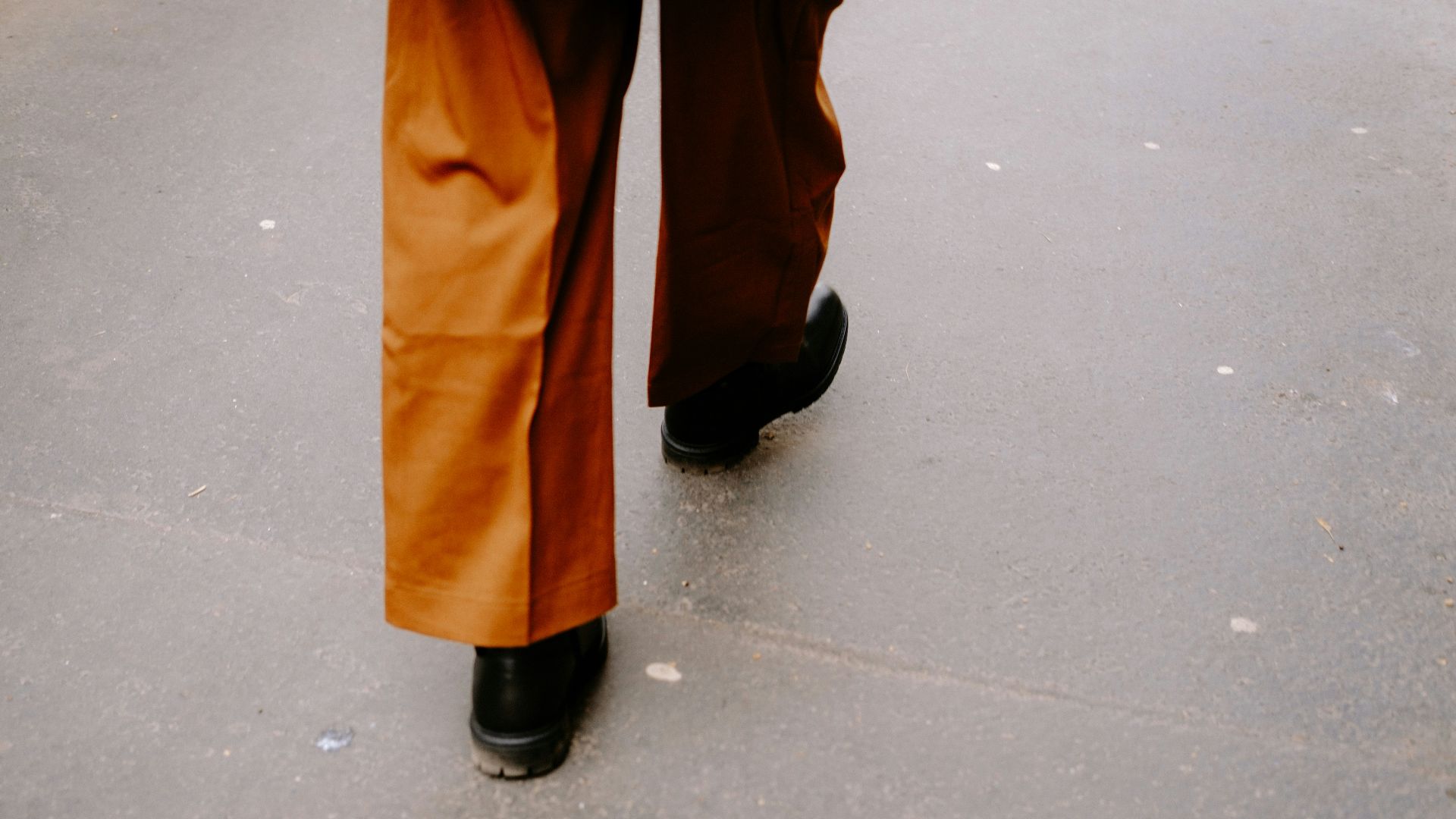 a person walking down a street with an umbrella over their head