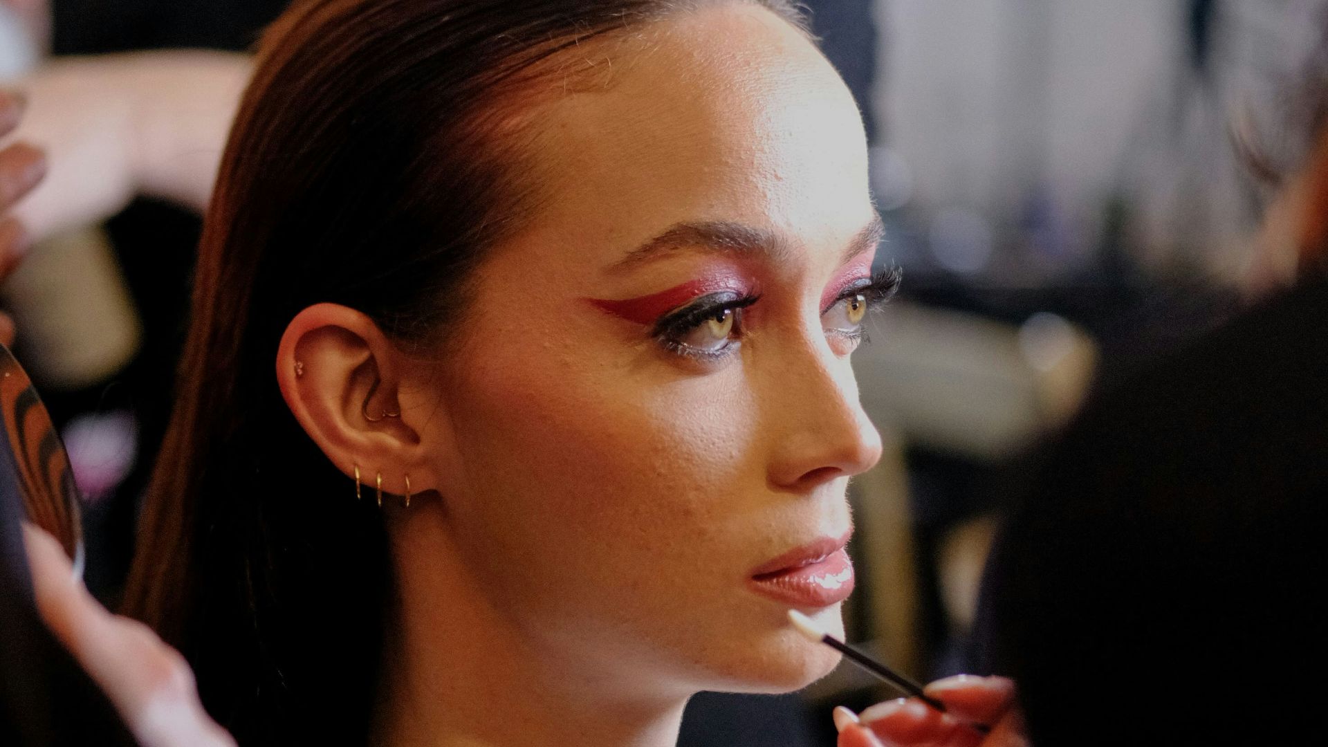 A woman getting her make - up done by a professional make - up artist