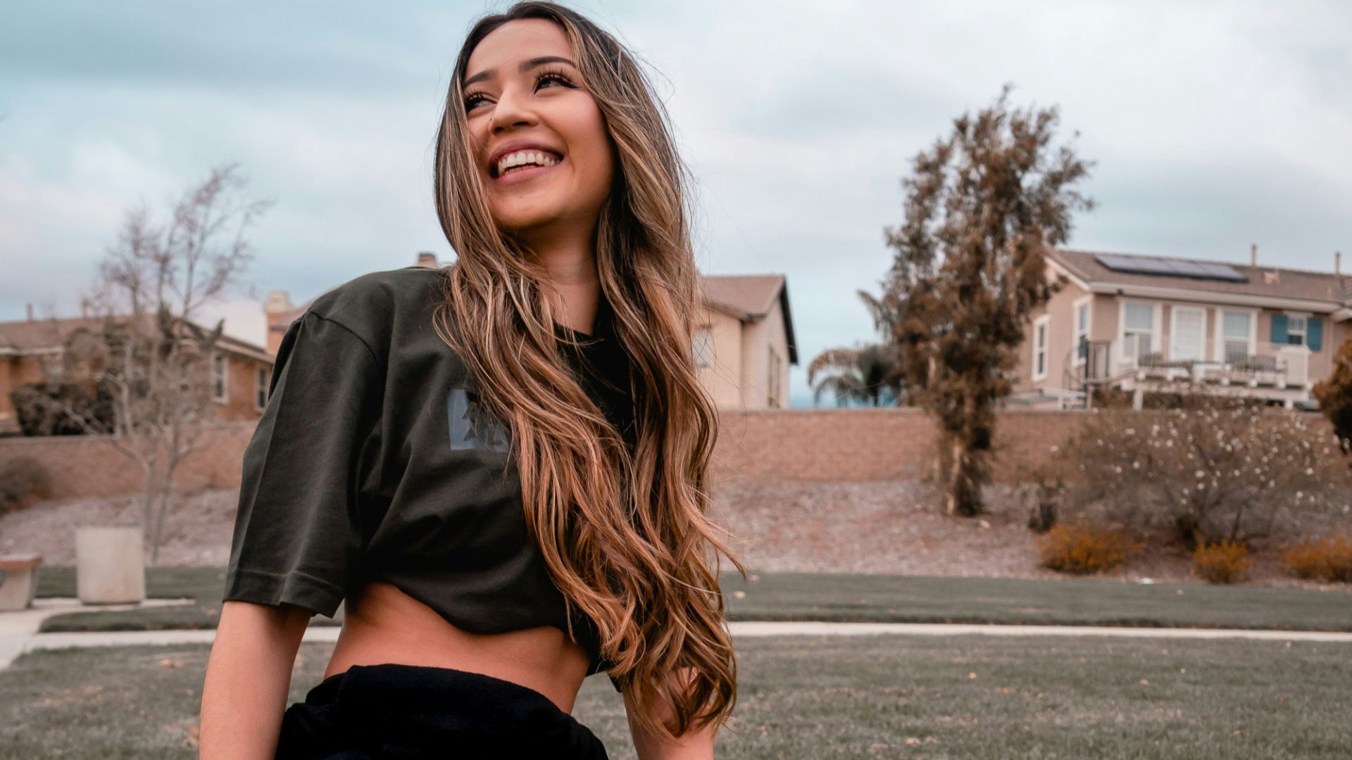 woman in black t-shirt and black pants sitting on ground during daytime