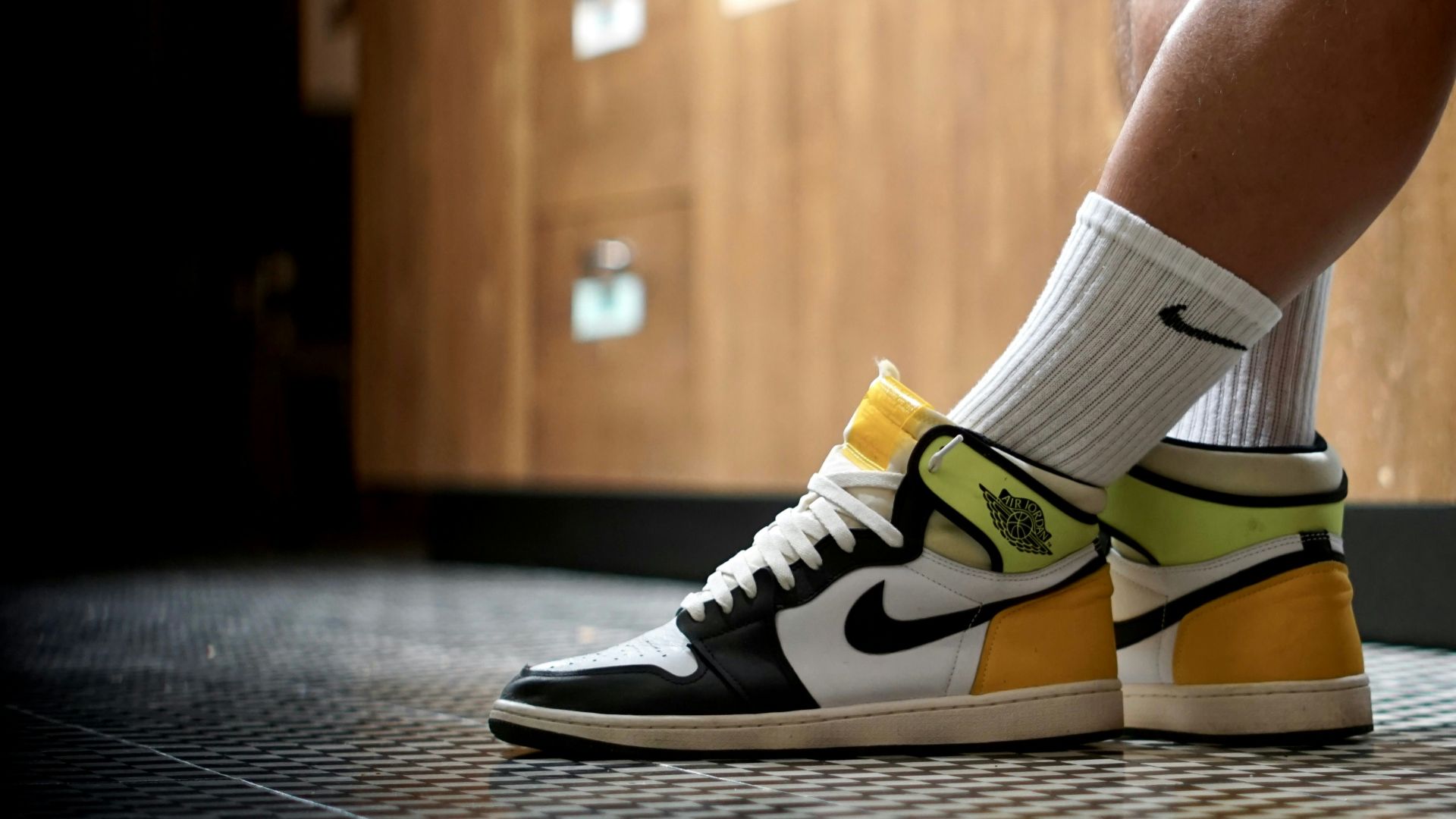 A man in black shorts and yellow and white sneakers