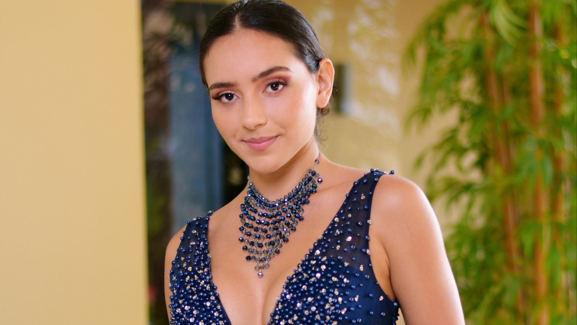 woman in blue and white sleeveless dress sitting on white couch