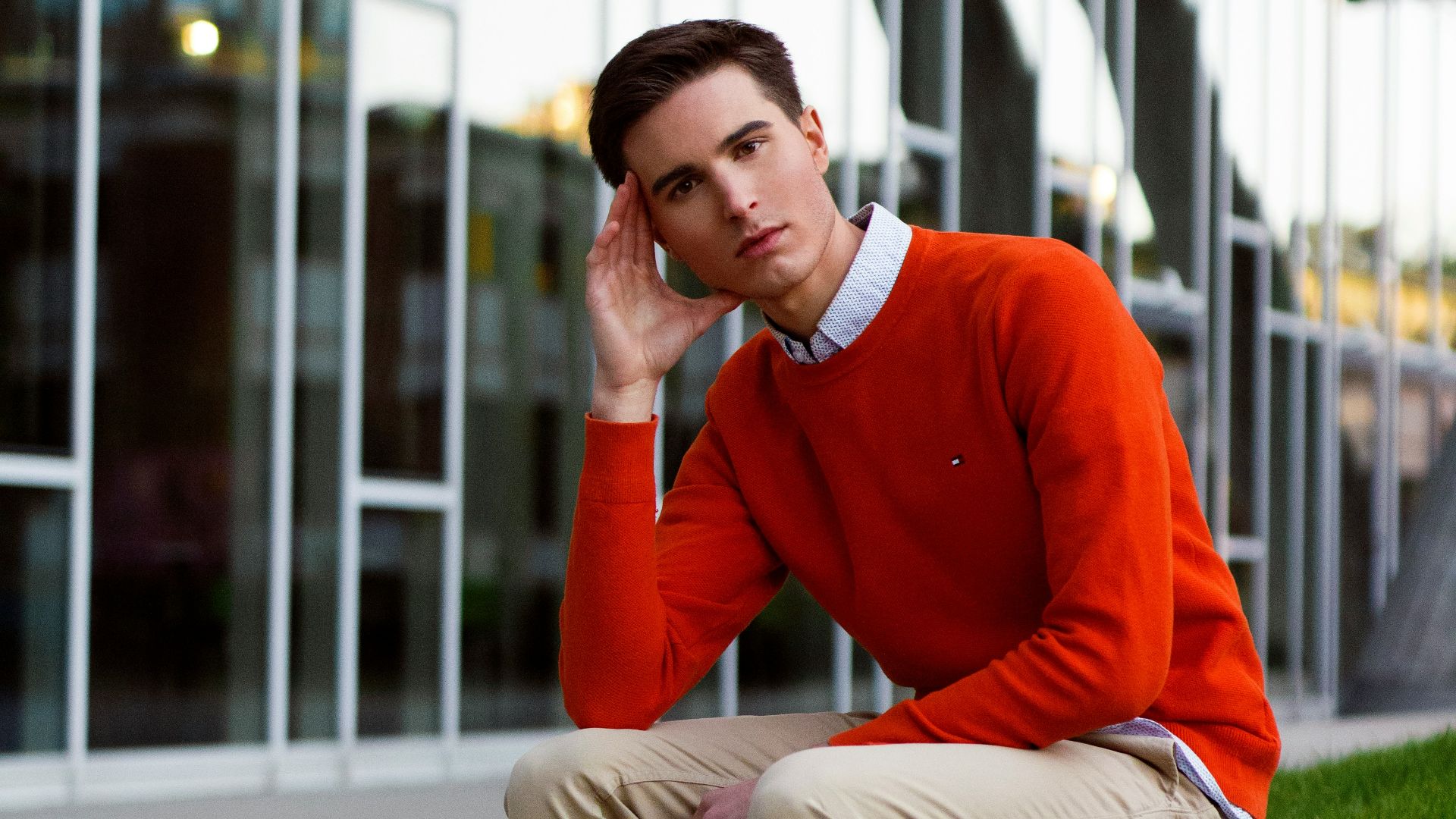 a man sitting on a bench in front of a building