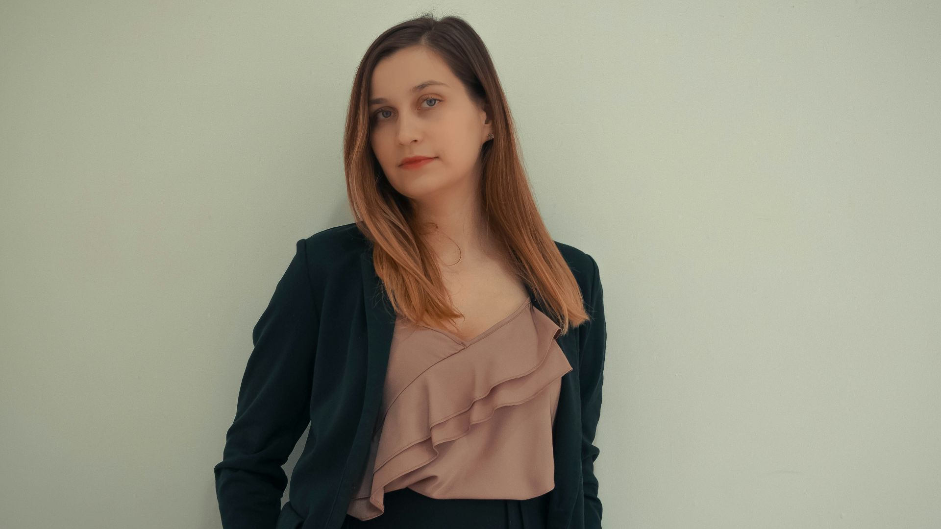 a woman standing in front of a white wall