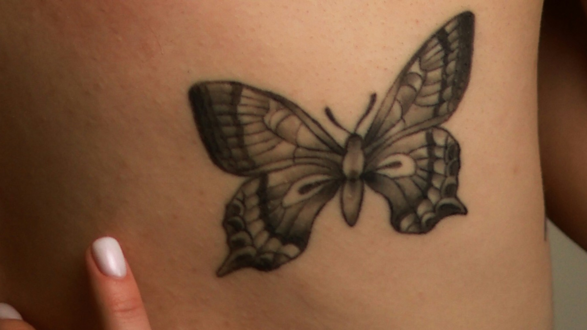 a woman with a butterfly tattoo on her back