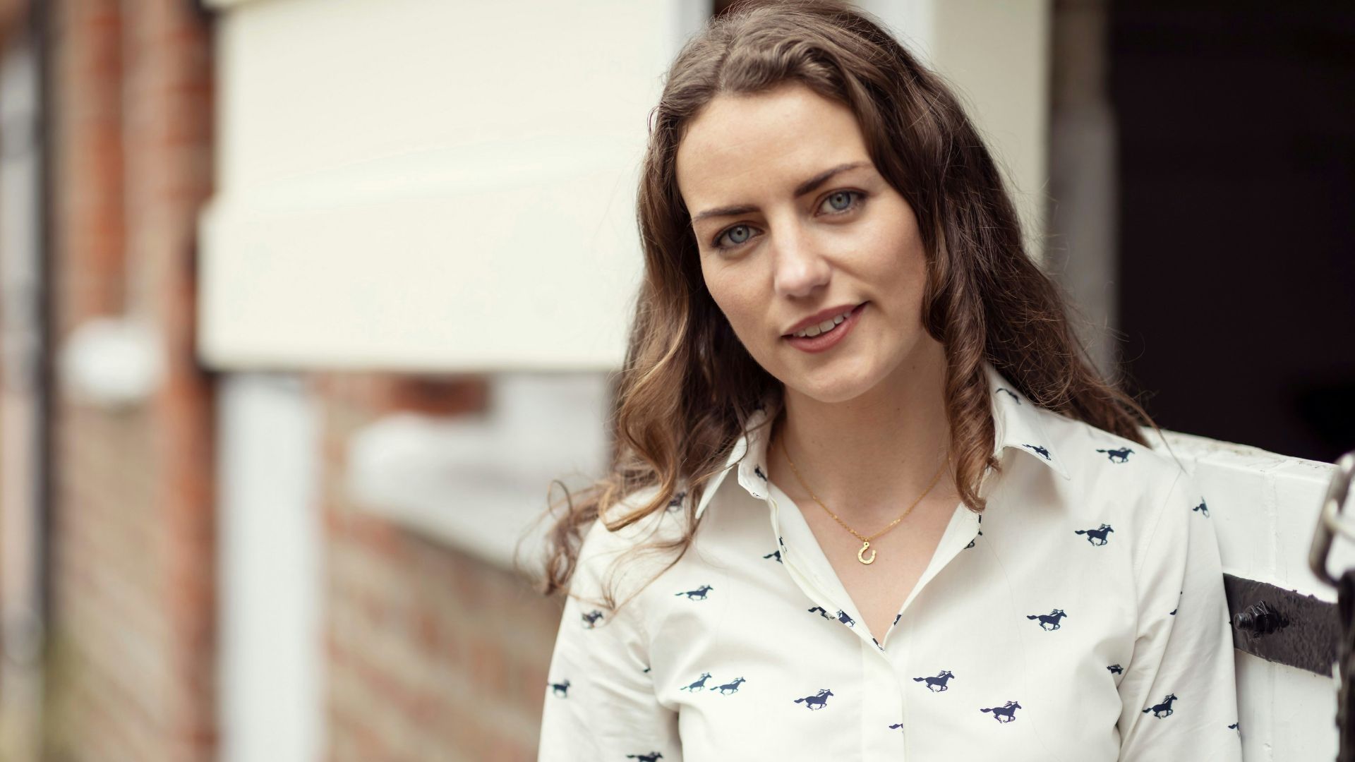 A woman in a white shirt is standing outside