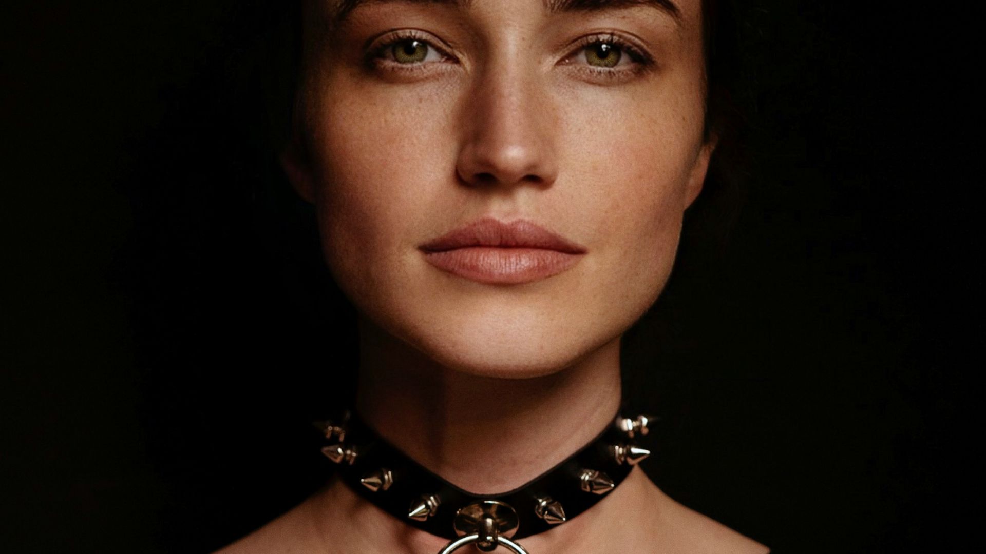 a woman wearing a necklace with a cross on it