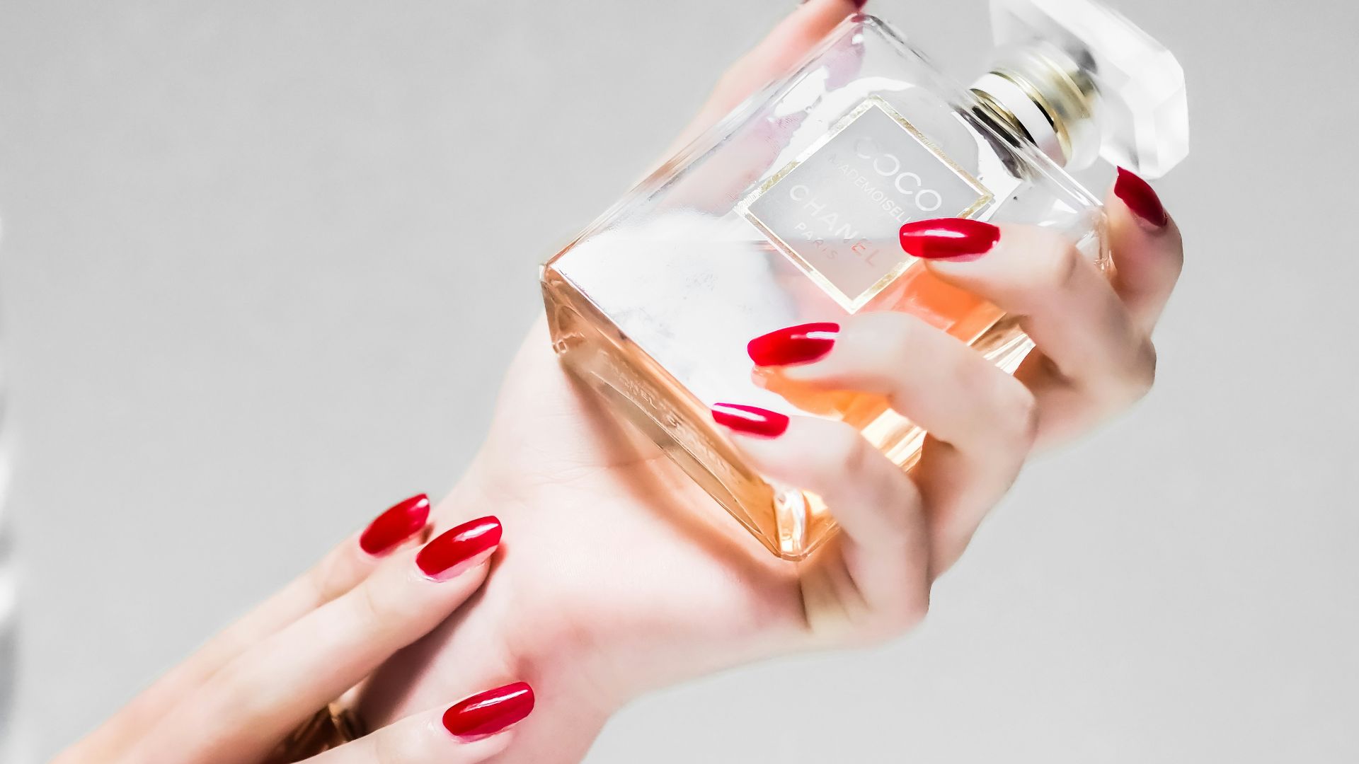 person holding clear glass bottle