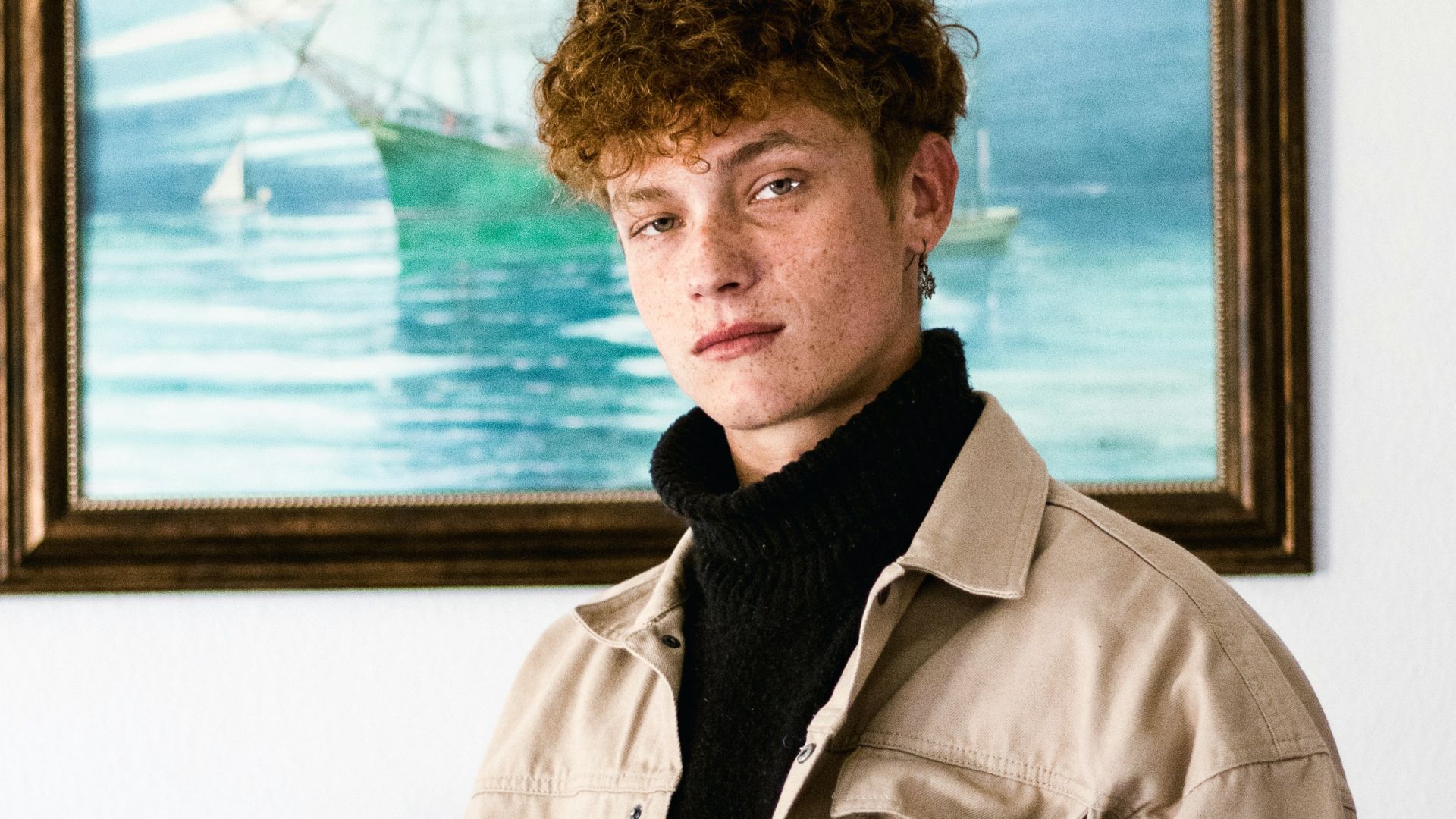 a man standing in front of a painting of a ship
