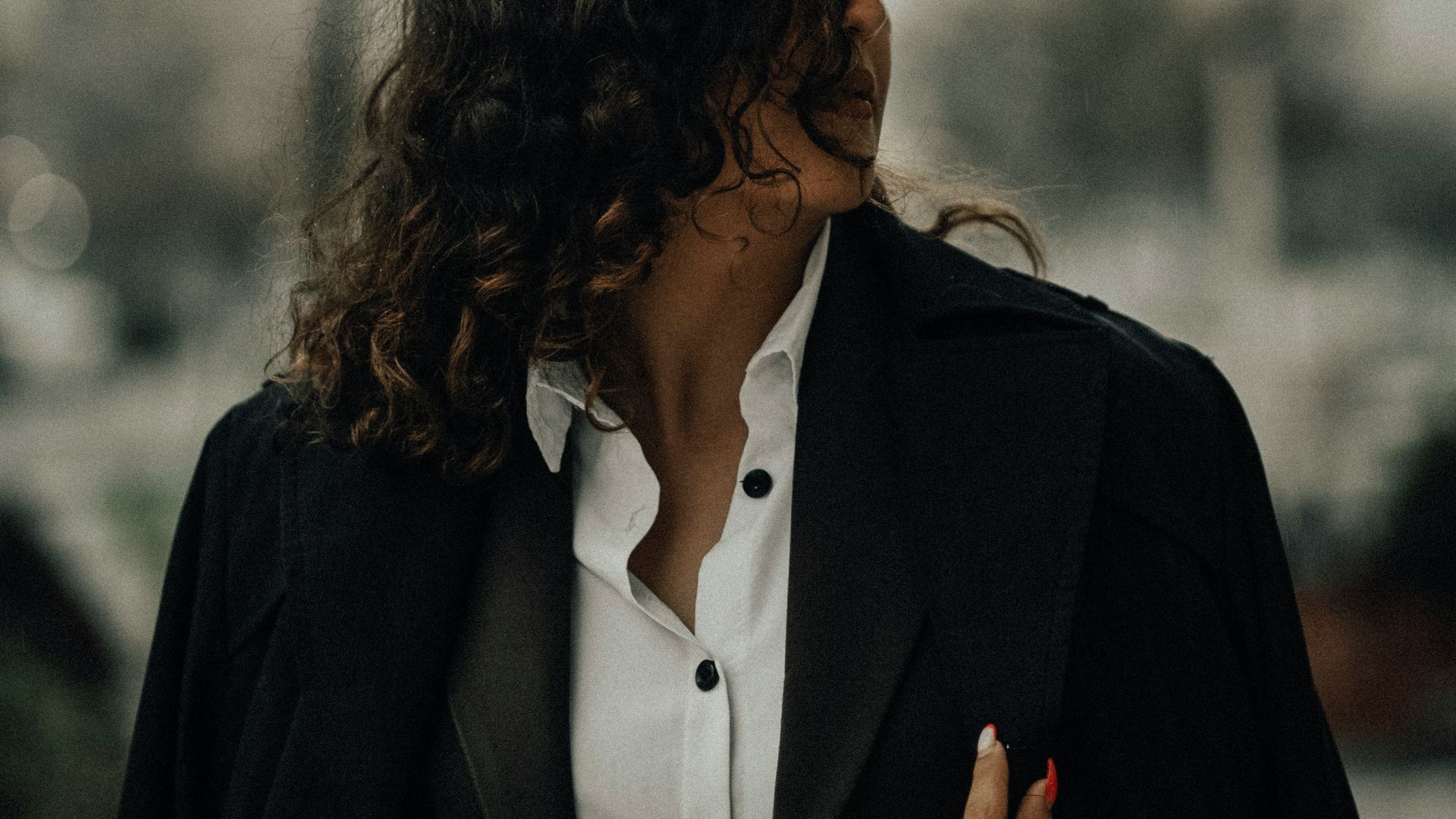 a woman wearing a black jacket and white shirt