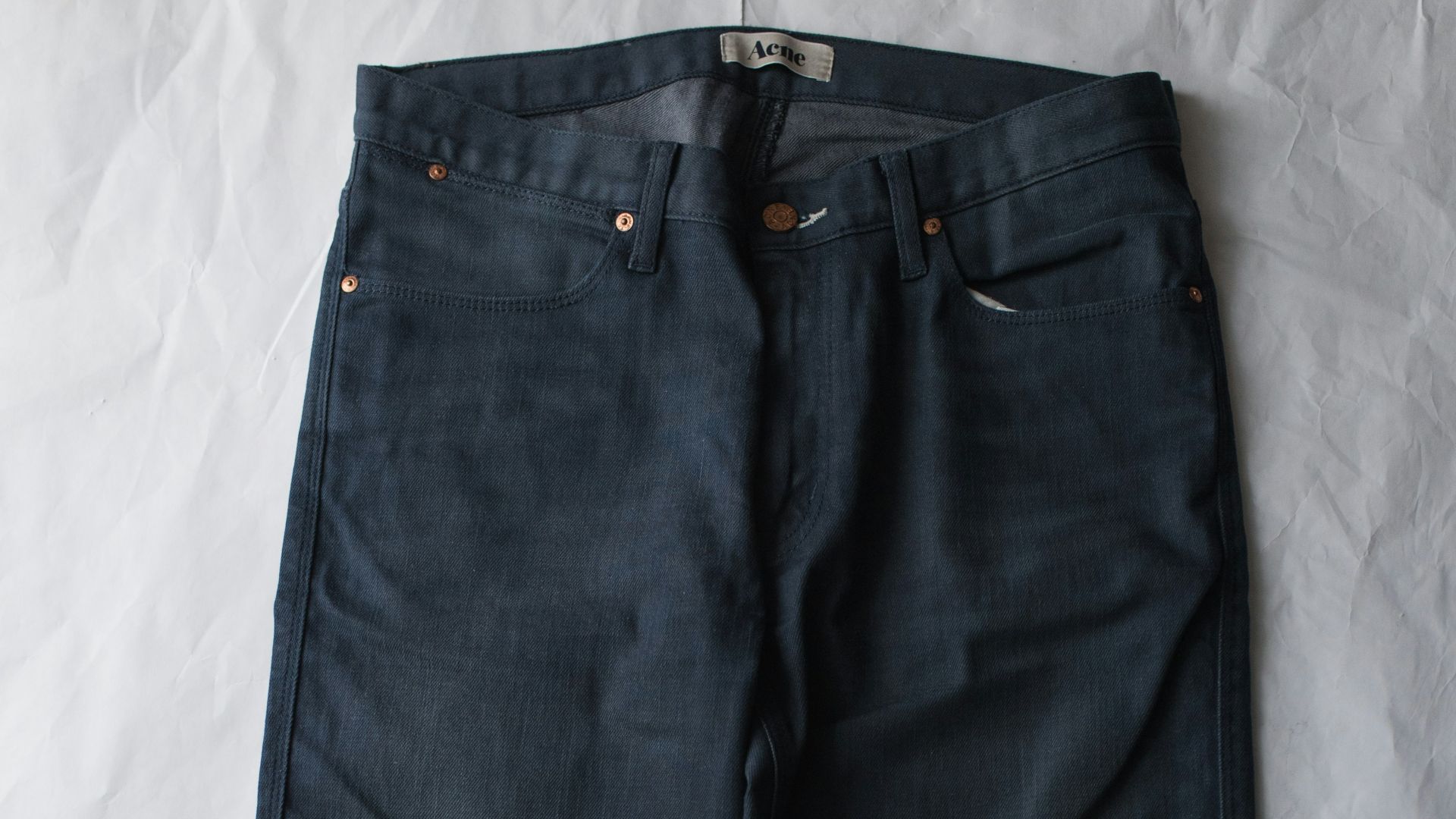 blue denim jeans on white textile