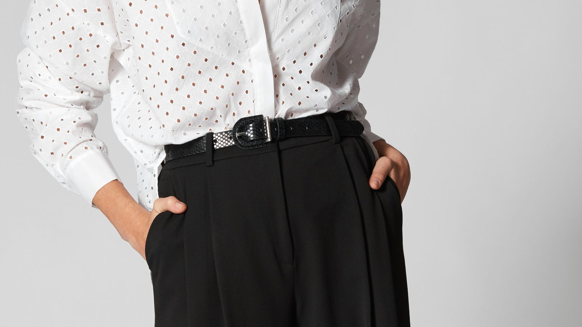 Woman in white shirt and black wide-leg pants.