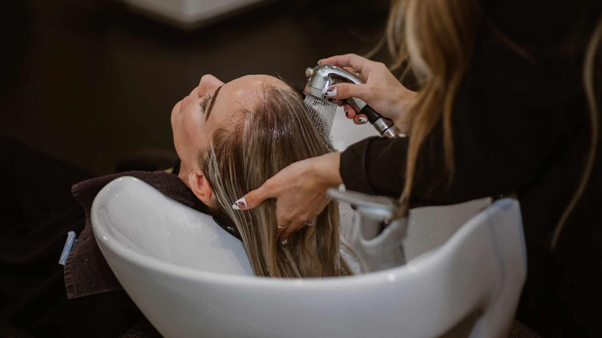 a woman getting her hair cut by a hair stylist