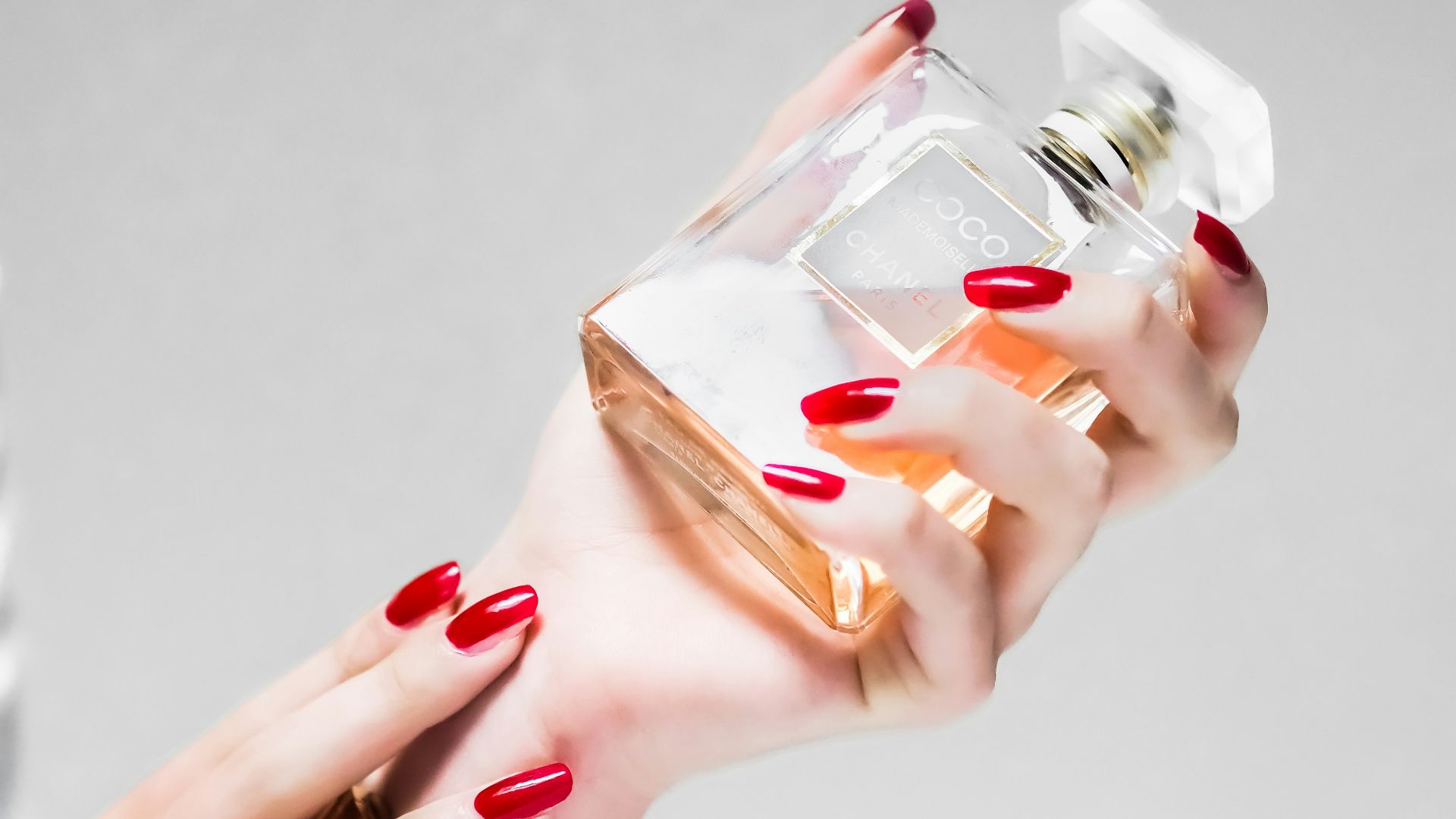 person holding clear glass bottle