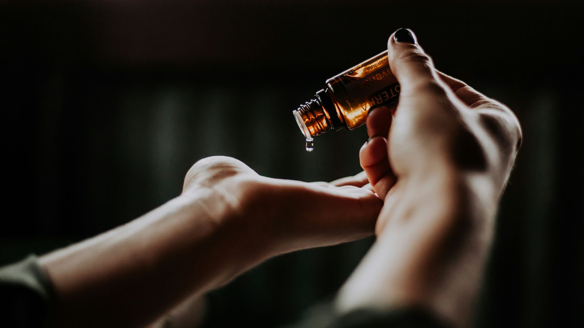 person holding amber glass bottle