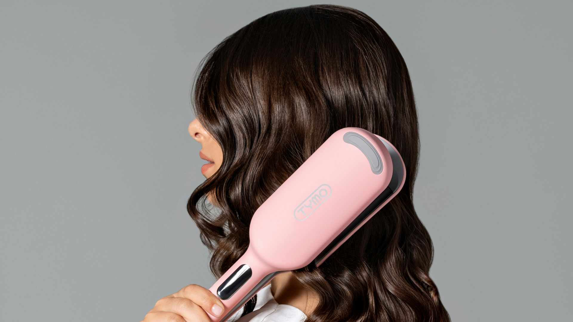 a woman blow drying her hair with a hair dryer