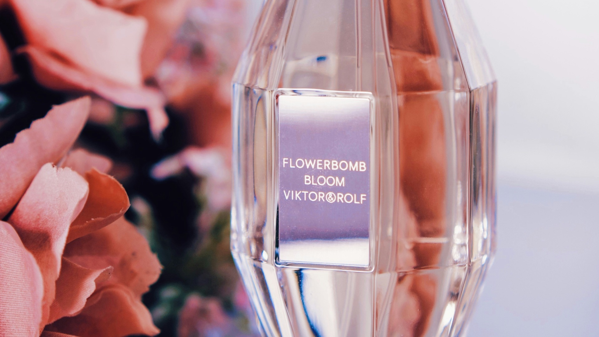 a bottle of perfume next to a bouquet of flowers