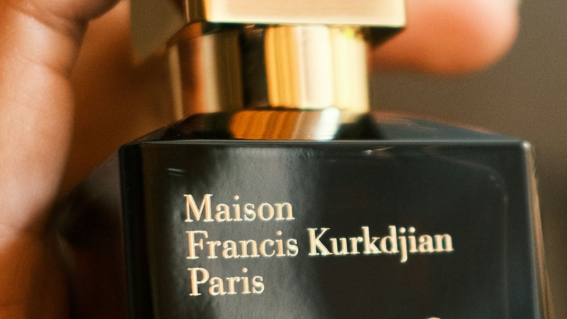 a person holding a bottle of perfume in their hand