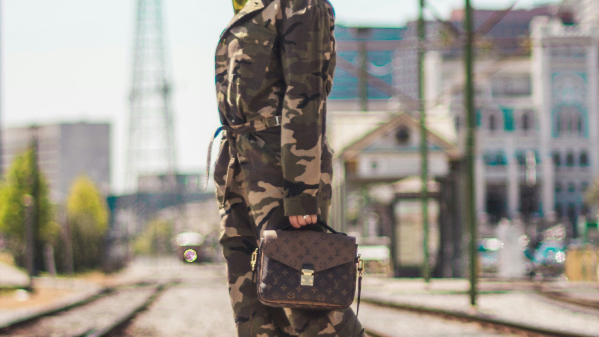 woman wearing camouflage soldier uniform carrying brown 2-way leather bag