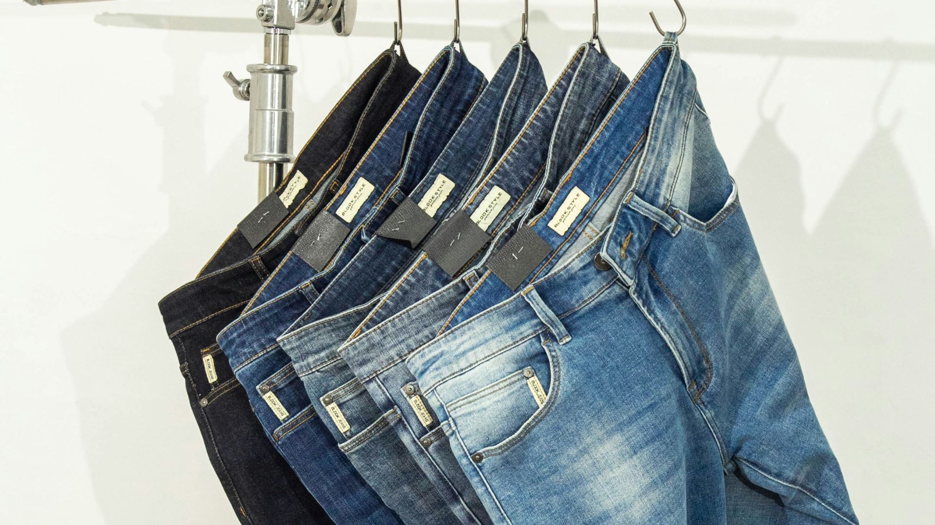 five pairs of jeans hanging on a clothes rack