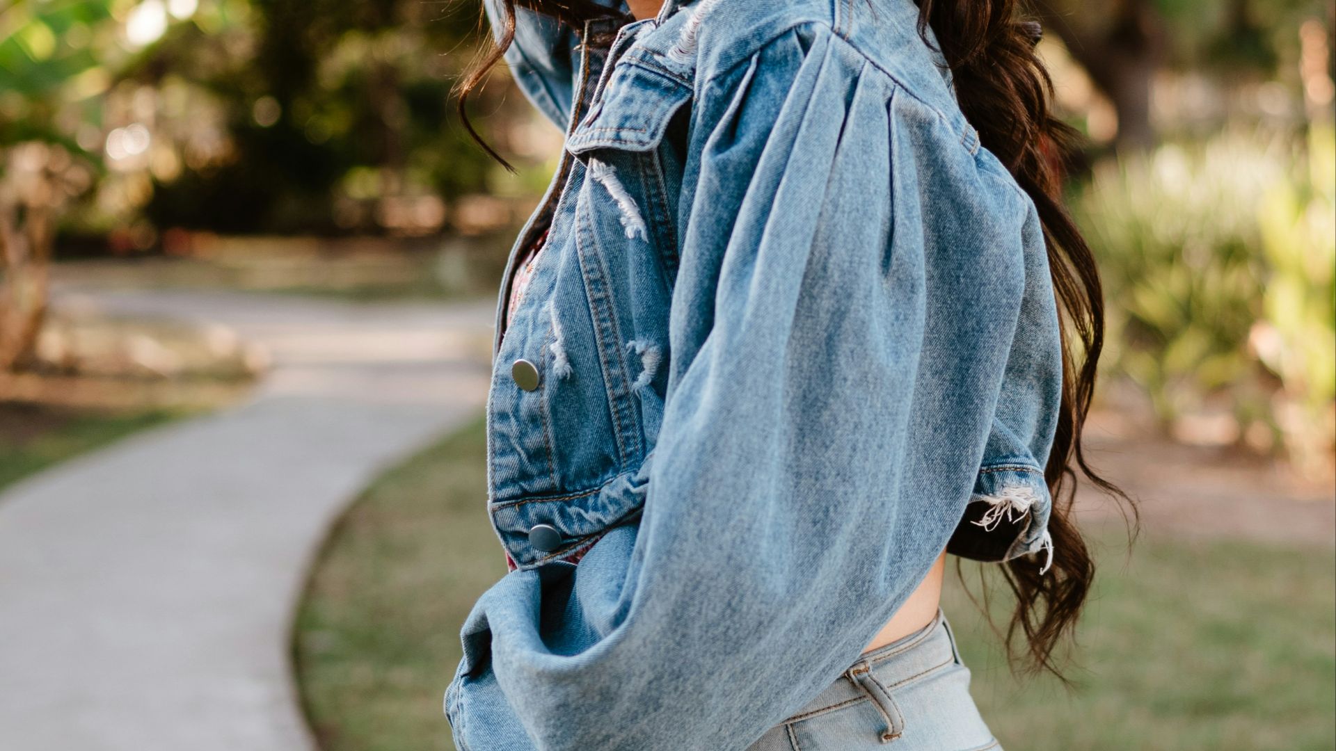 Young woman with pink sunglasses in denim jacket