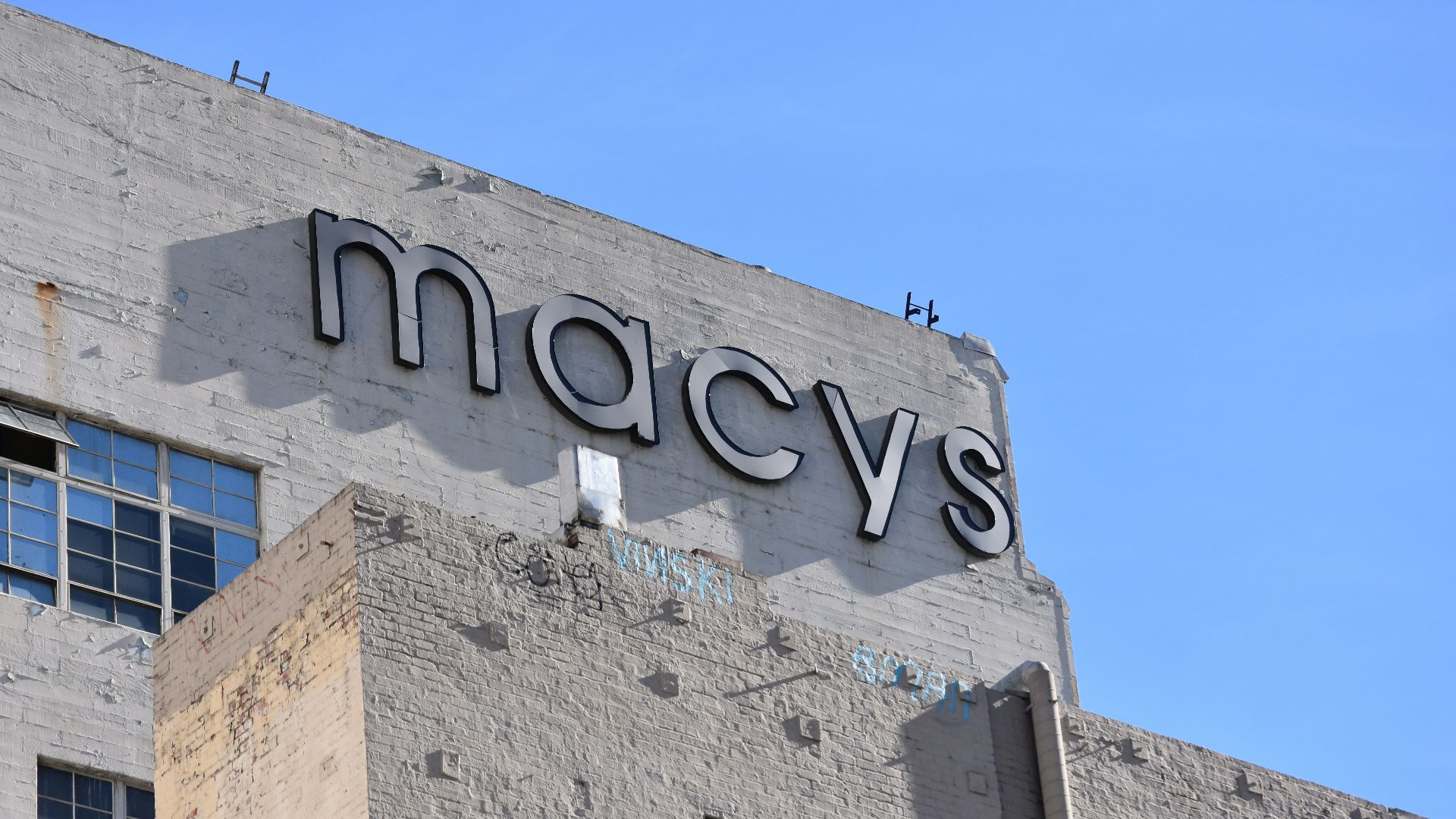 low angle photo of gray concrete building under blue sky during daytime