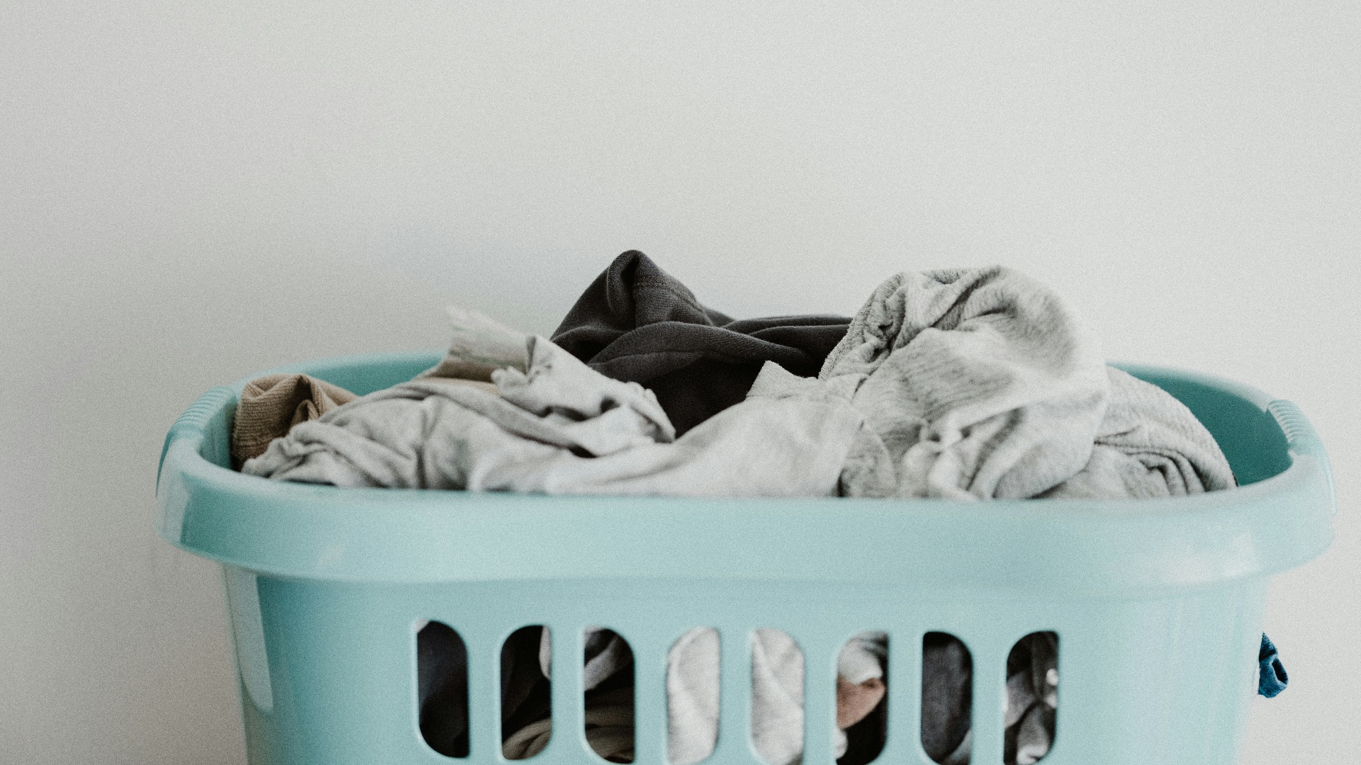 white textile on blue plastic laundry basket