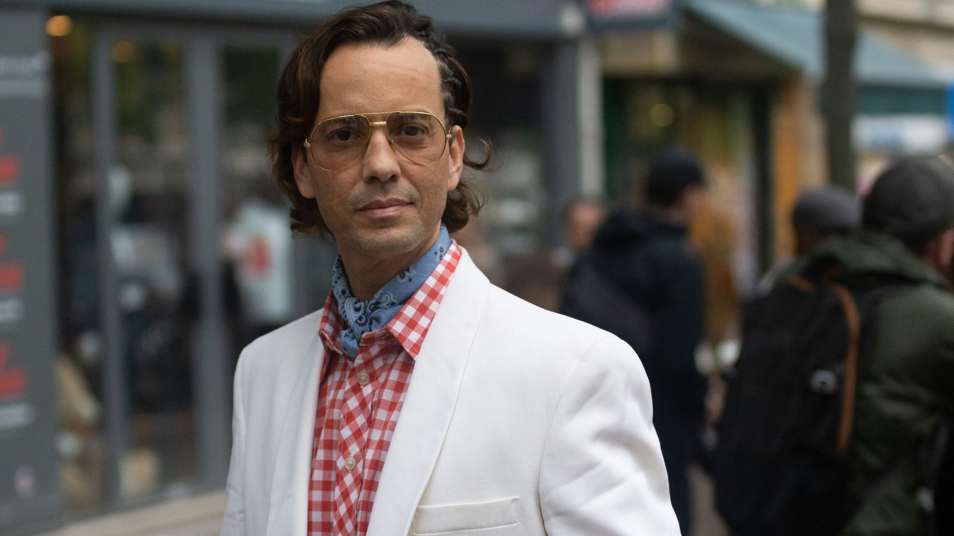 a man in a white coat and red tie