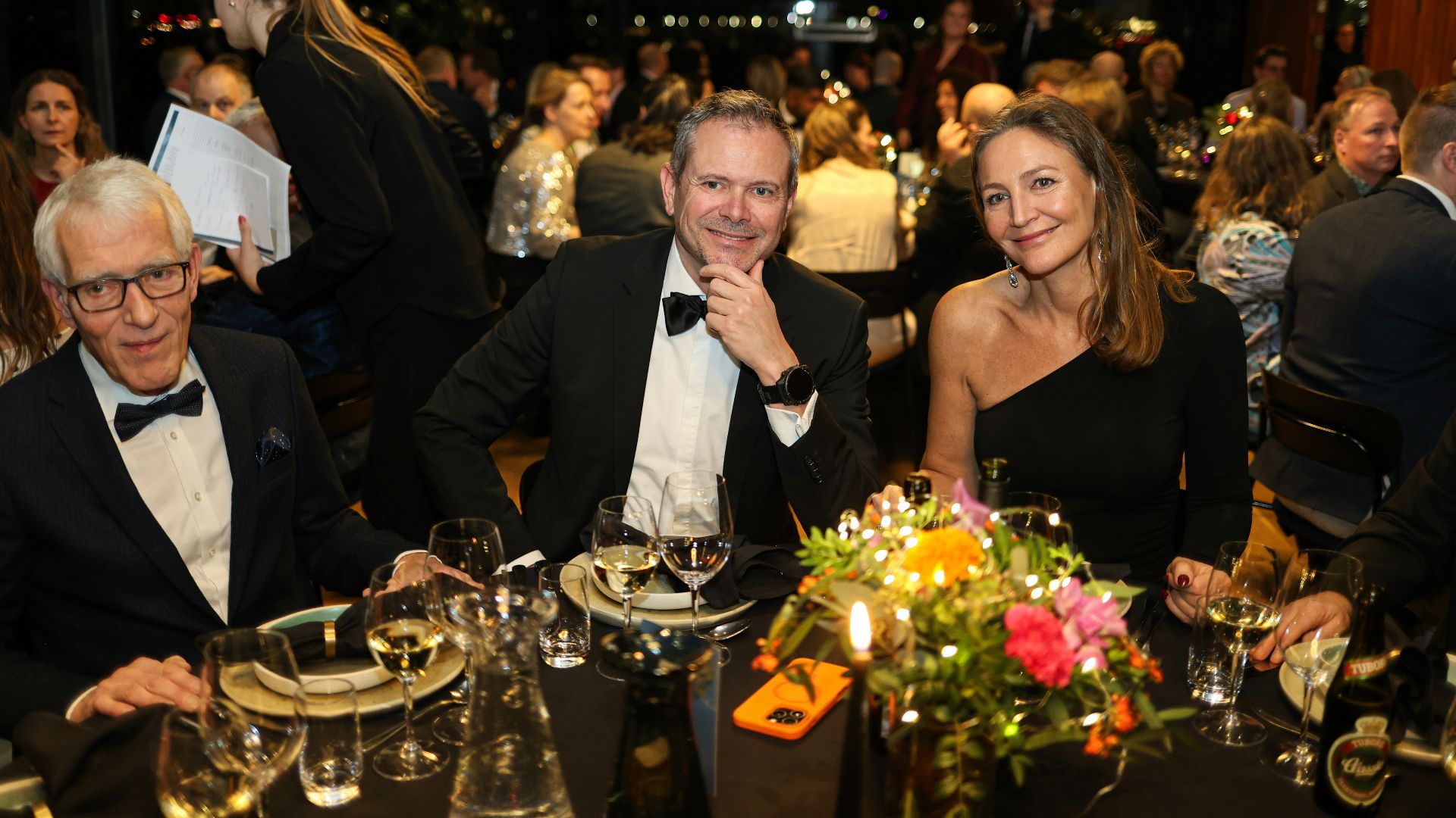 Three people at a formal dinner event