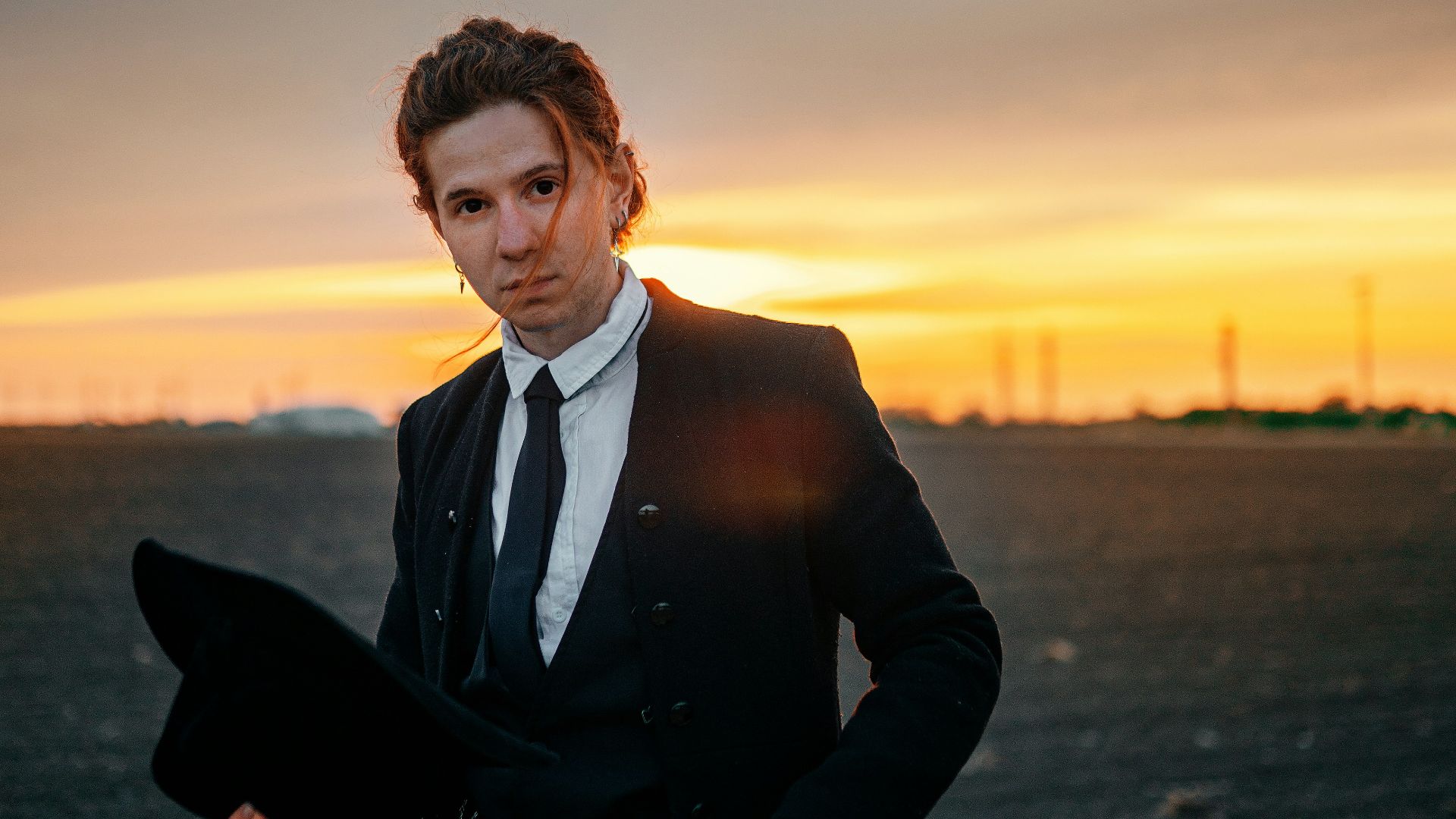A man in a suit and tie standing in a field