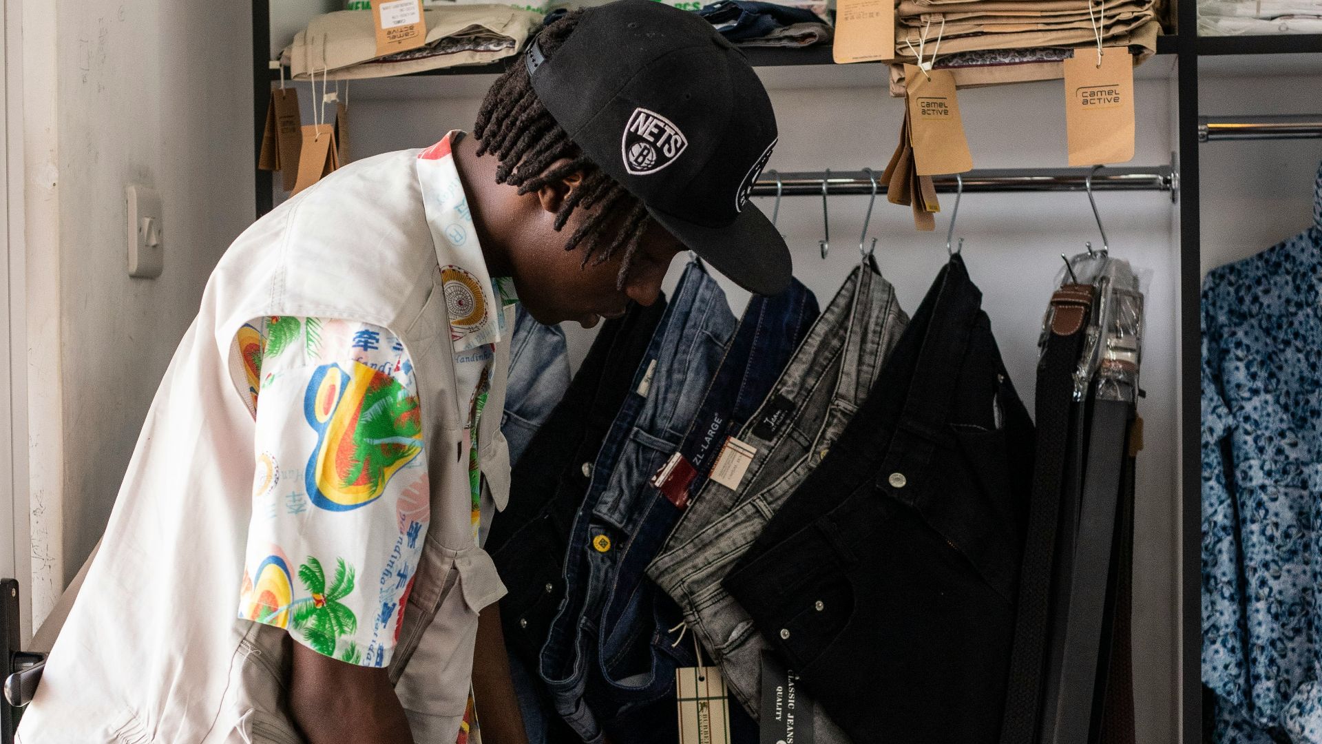 A man standing in front of a closet filled with clothes