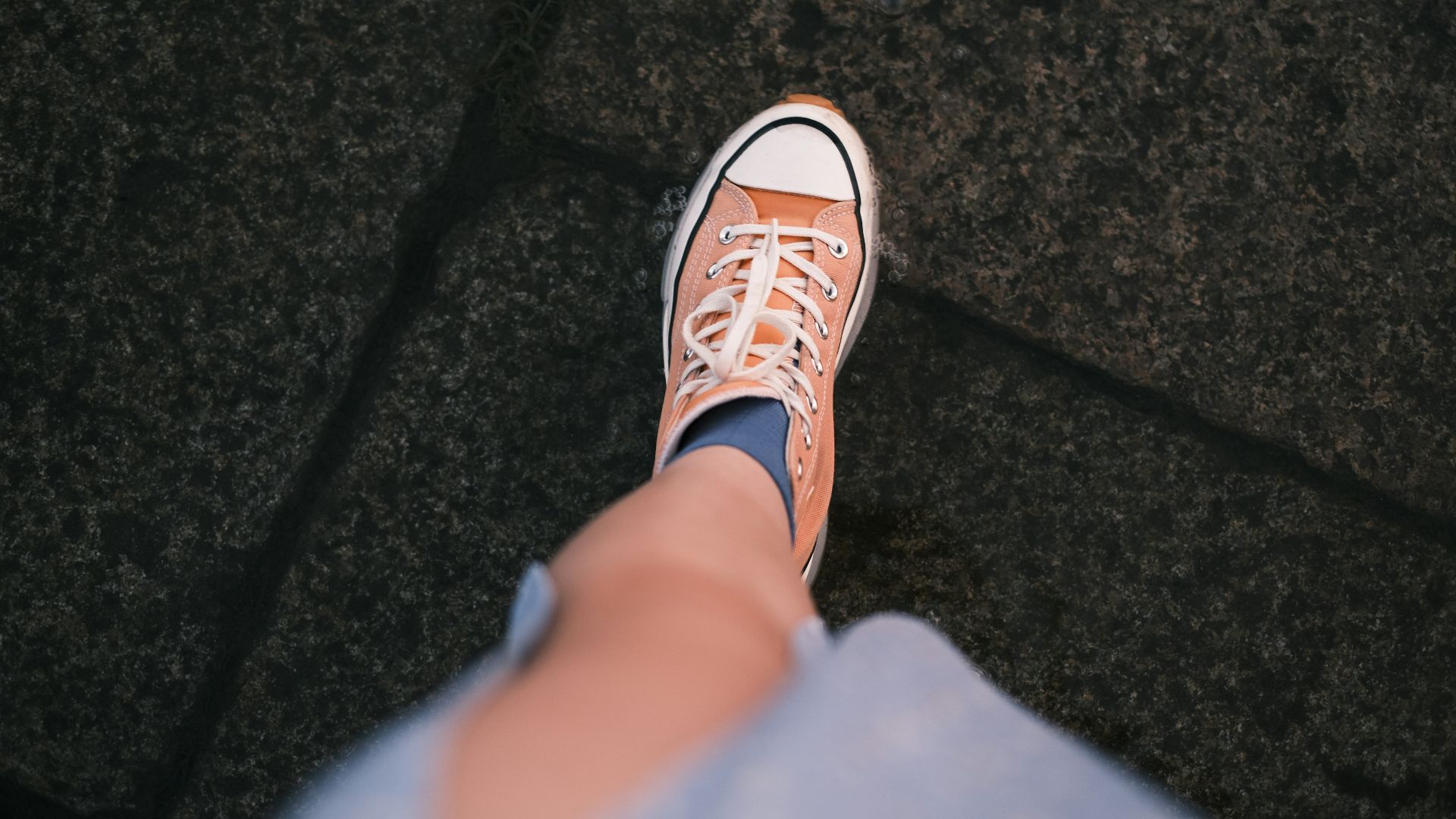 a person's feet with a pair of tennis shoes on