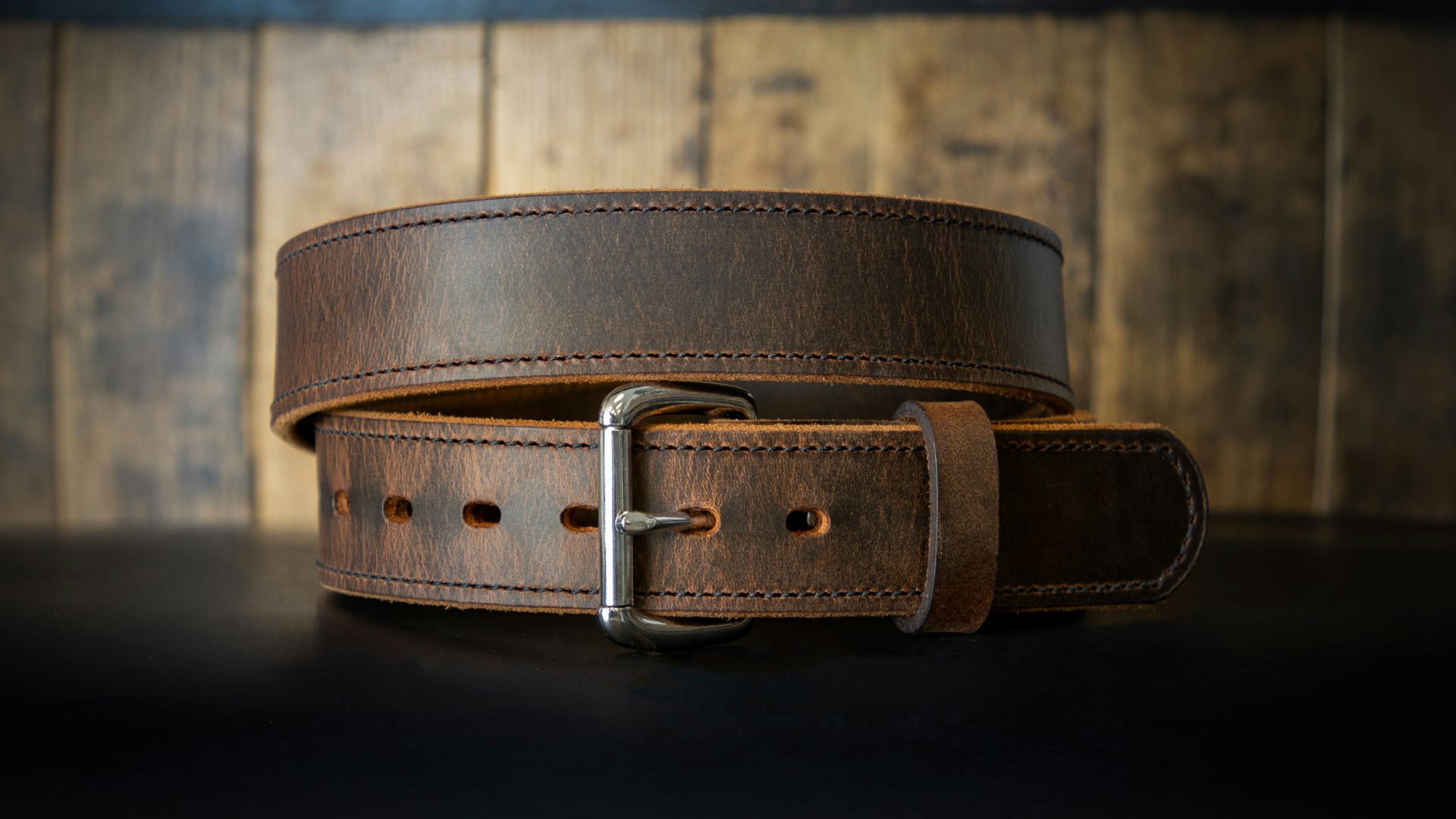 a leather belt on a black surface
