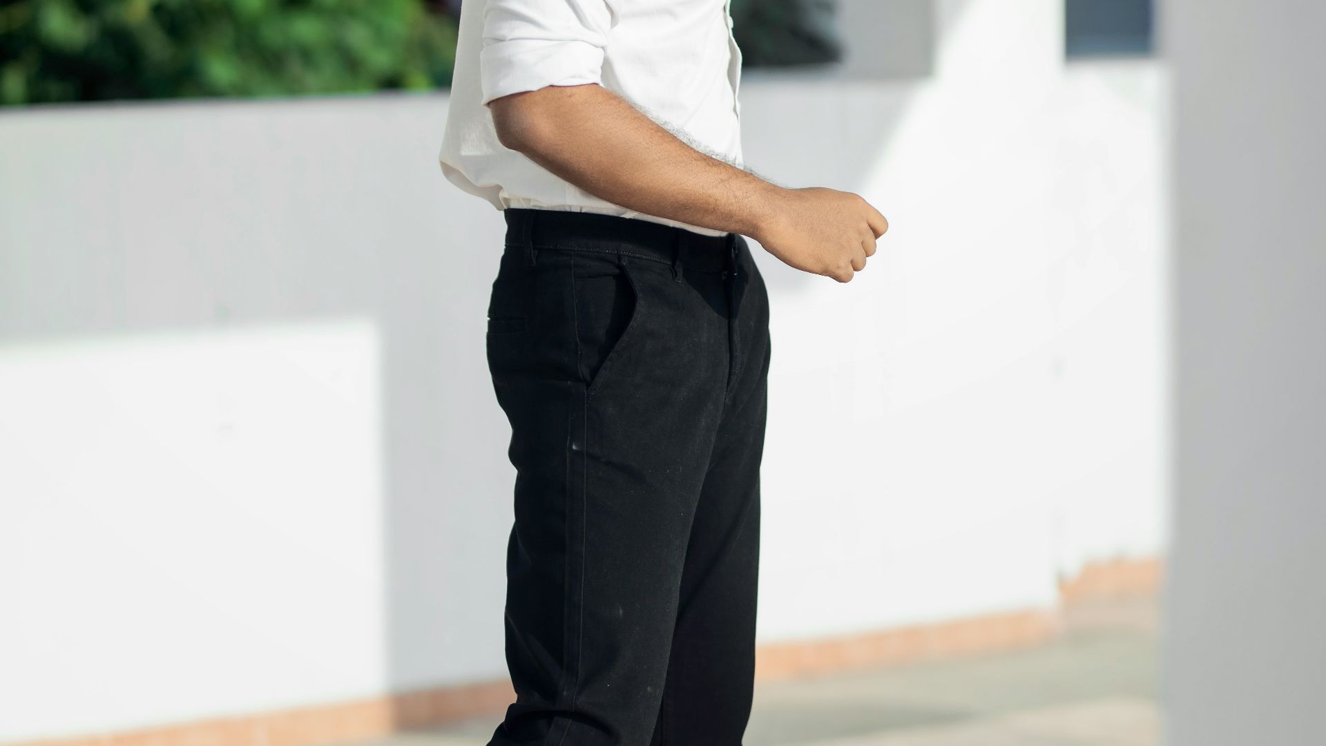 man in white t-shirt and black pants standing on white floor